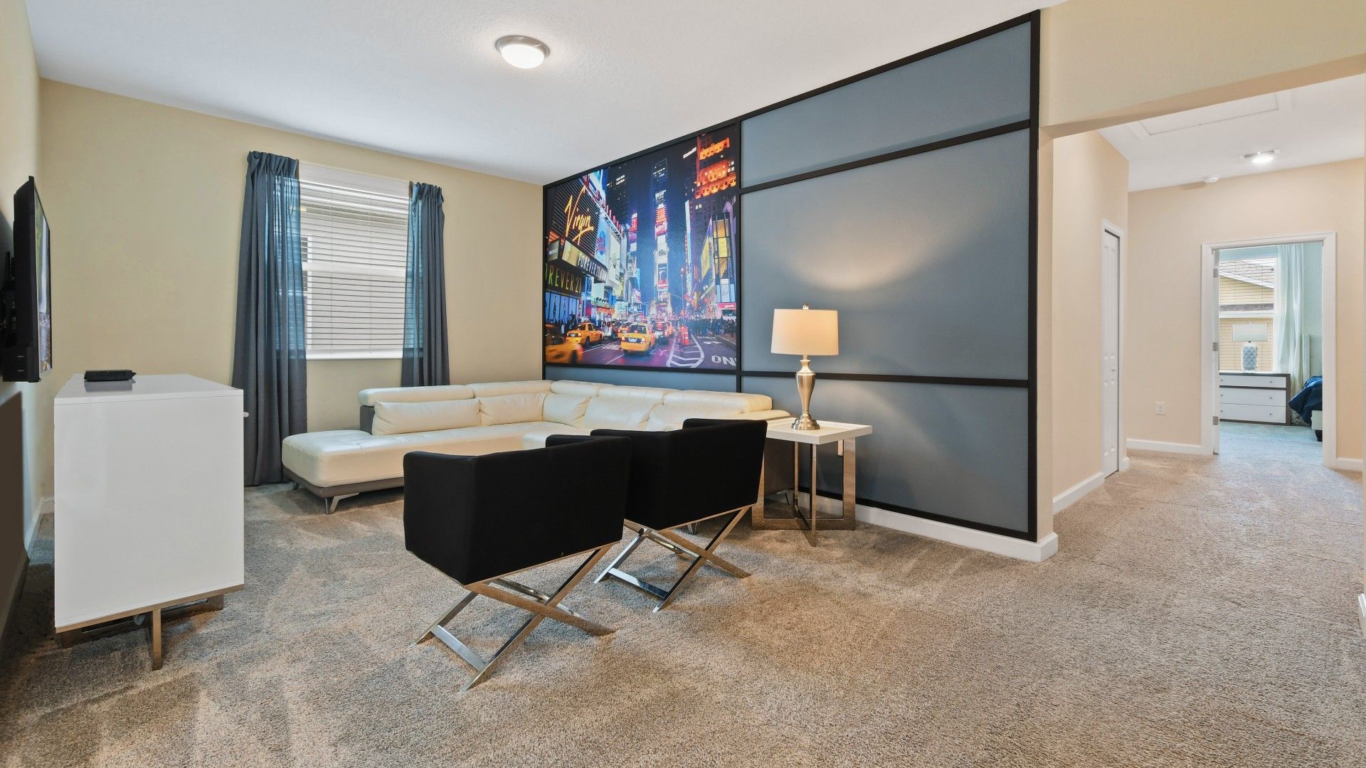 Stylish lounge with a sleek sectional, modern decor, and a vibrant cityscape mural