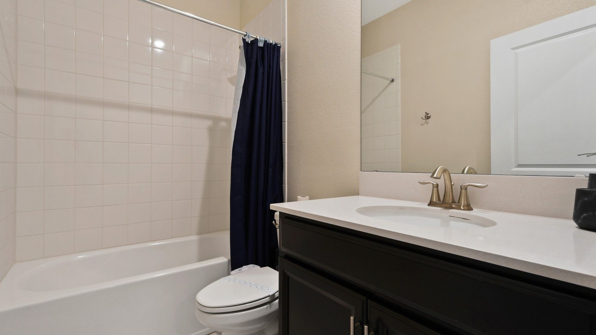 Modern bathroom with a sleek vanity, bright lighting, and a clean tub-shower combo