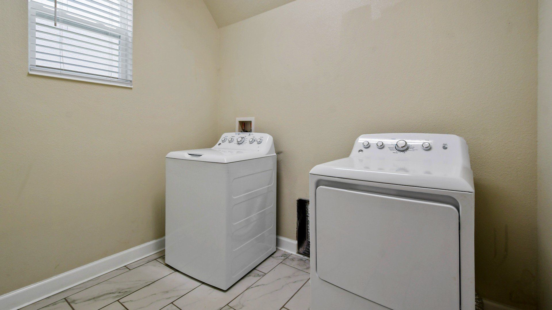 Spacious laundry room with a washer, dryer, and bright natural lighting for convenience