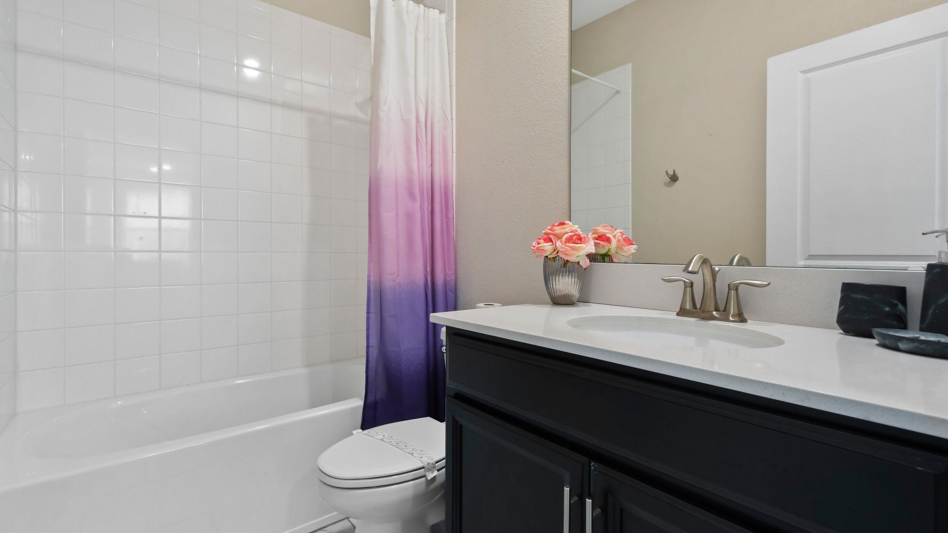 Modern and stylish bathroom with elegant finishes, a vibrant shower curtain, and a clean design