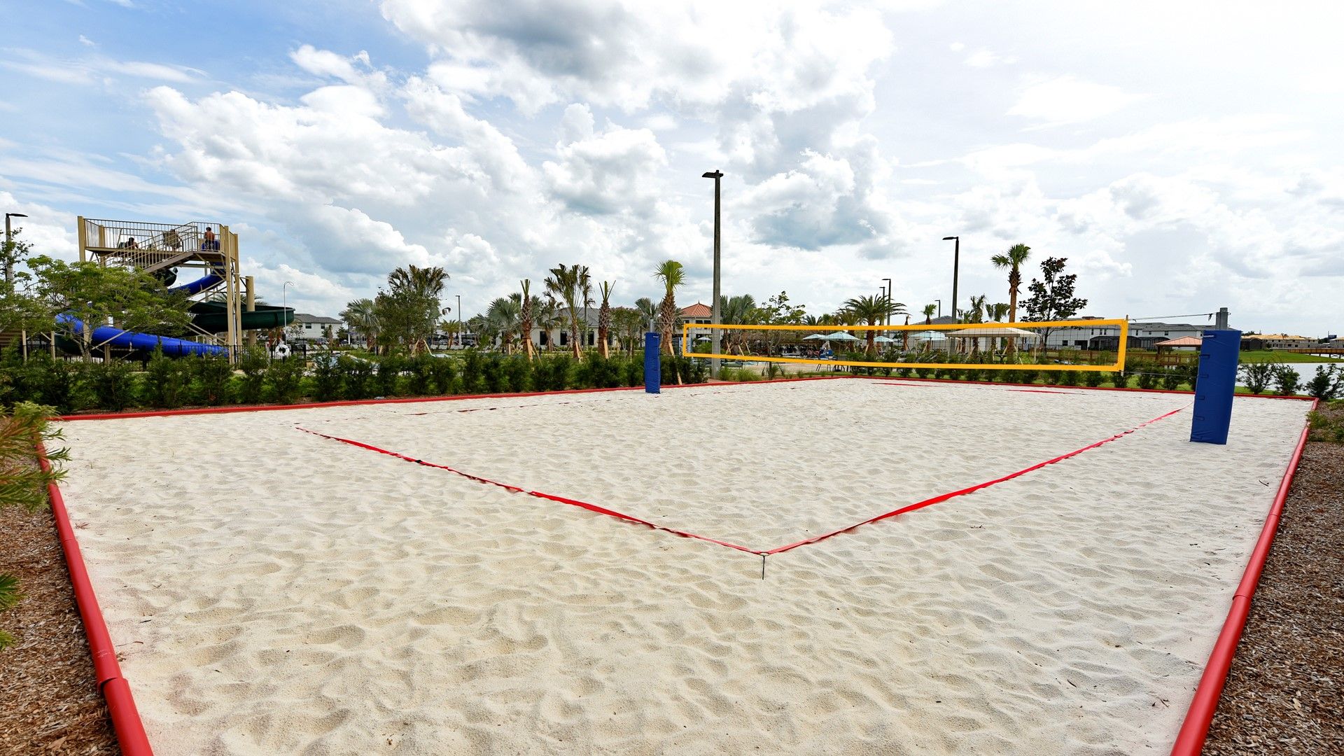 Serve, spike, and dive on a pristine sand volleyball court by the water.