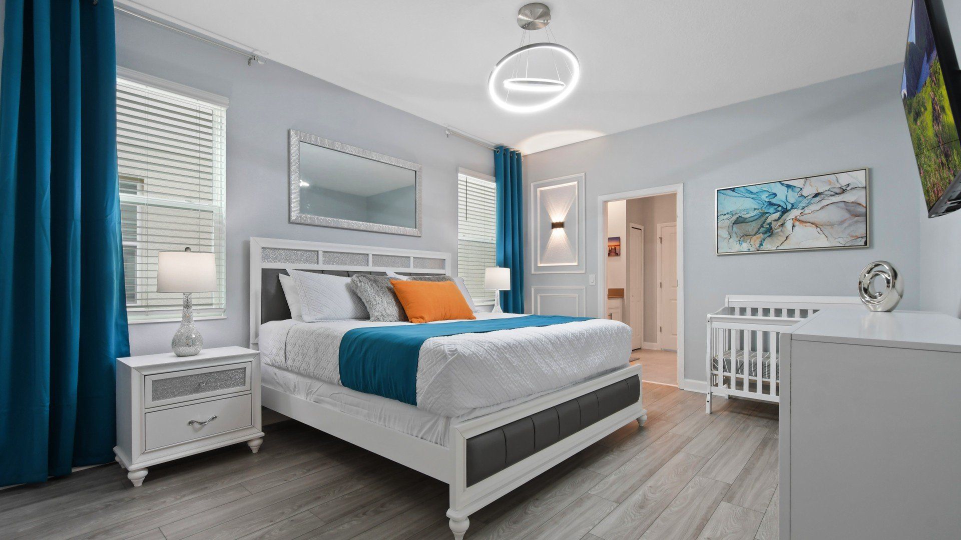 The master bedroom features a luxuriously large king bed with a crib