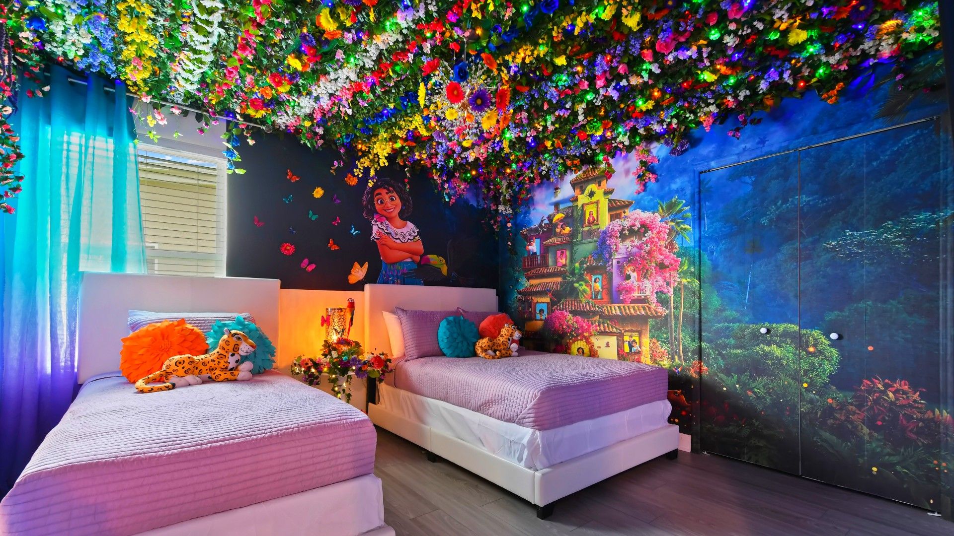 Vibrant Encanto-themed bedroom with colorful florals, magical murals, and cozy beds.