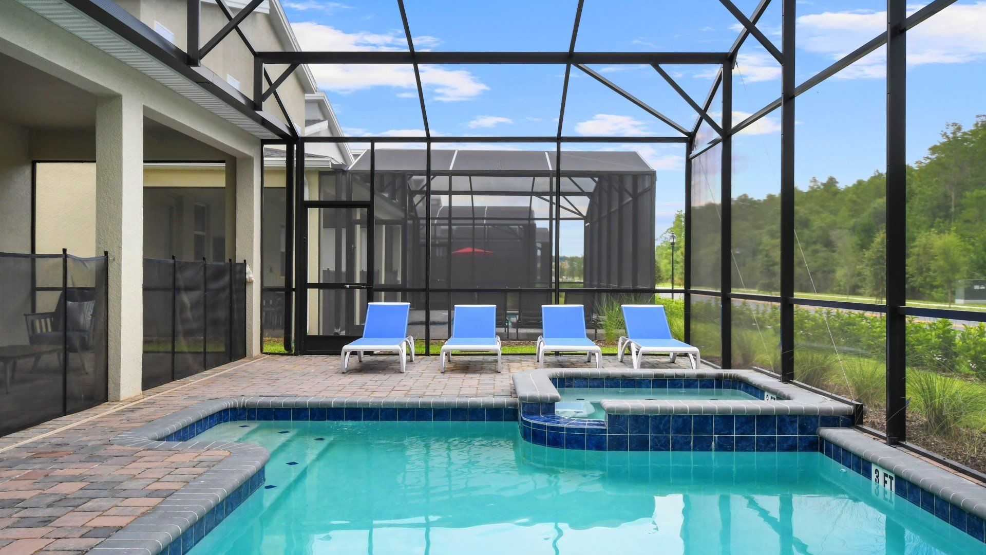 Screened-in private pool and spa with lounge chairs, surrounded by peaceful nature.