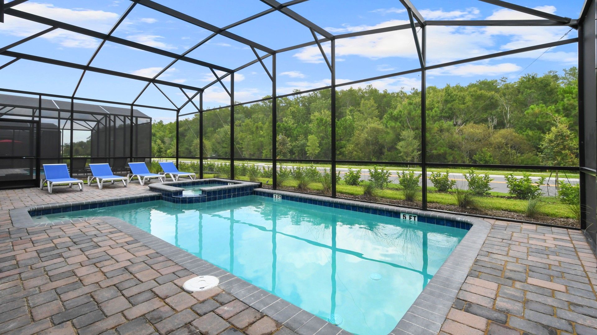 Screened-in private pool and spa with lounge chairs, surrounded by peaceful nature.