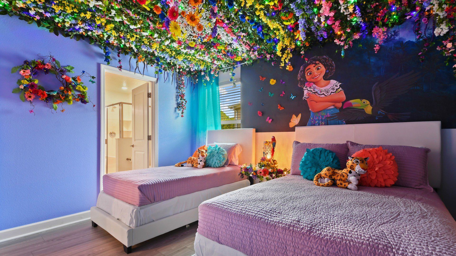 Vibrant Encanto-themed bedroom with colorful florals, magical murals, and cozy beds.