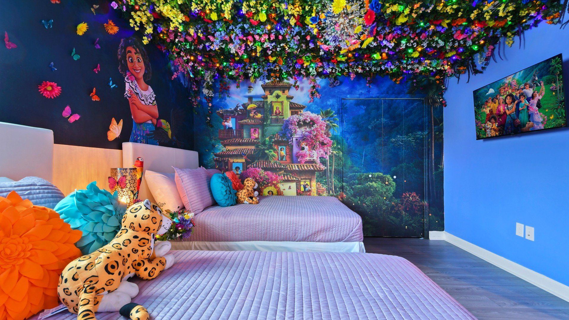 Vibrant Encanto-themed bedroom with colorful florals, magical murals, and cozy beds.