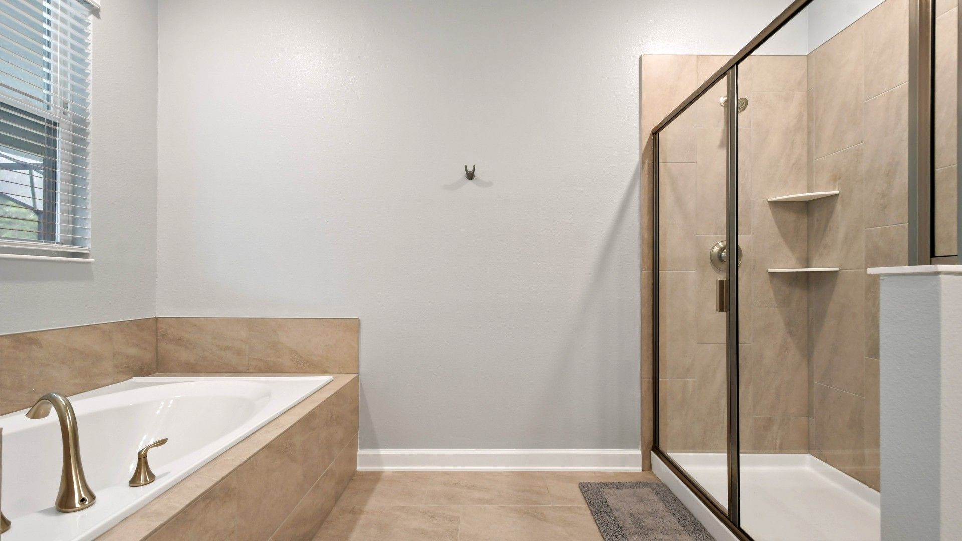 Spacious modern bathroom with a soaking tub, glass-enclosed shower, and elegant finishes.