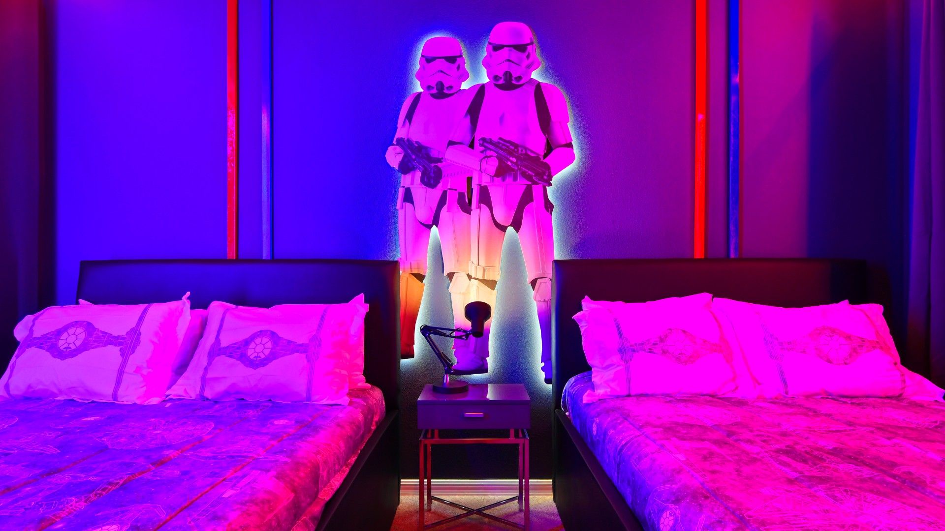 Galactic Star Wars-themed room with glowing decor, twin beds, and epic ambiance!