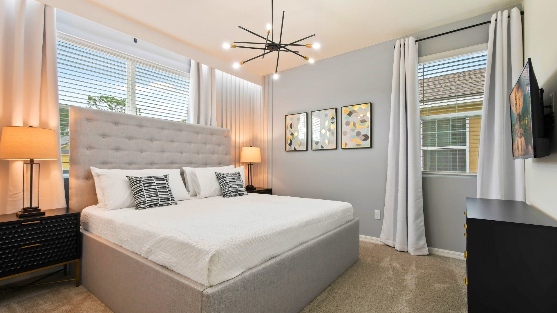 Chic modern bedroom with cozy king bed, stylish decor, and natural light!