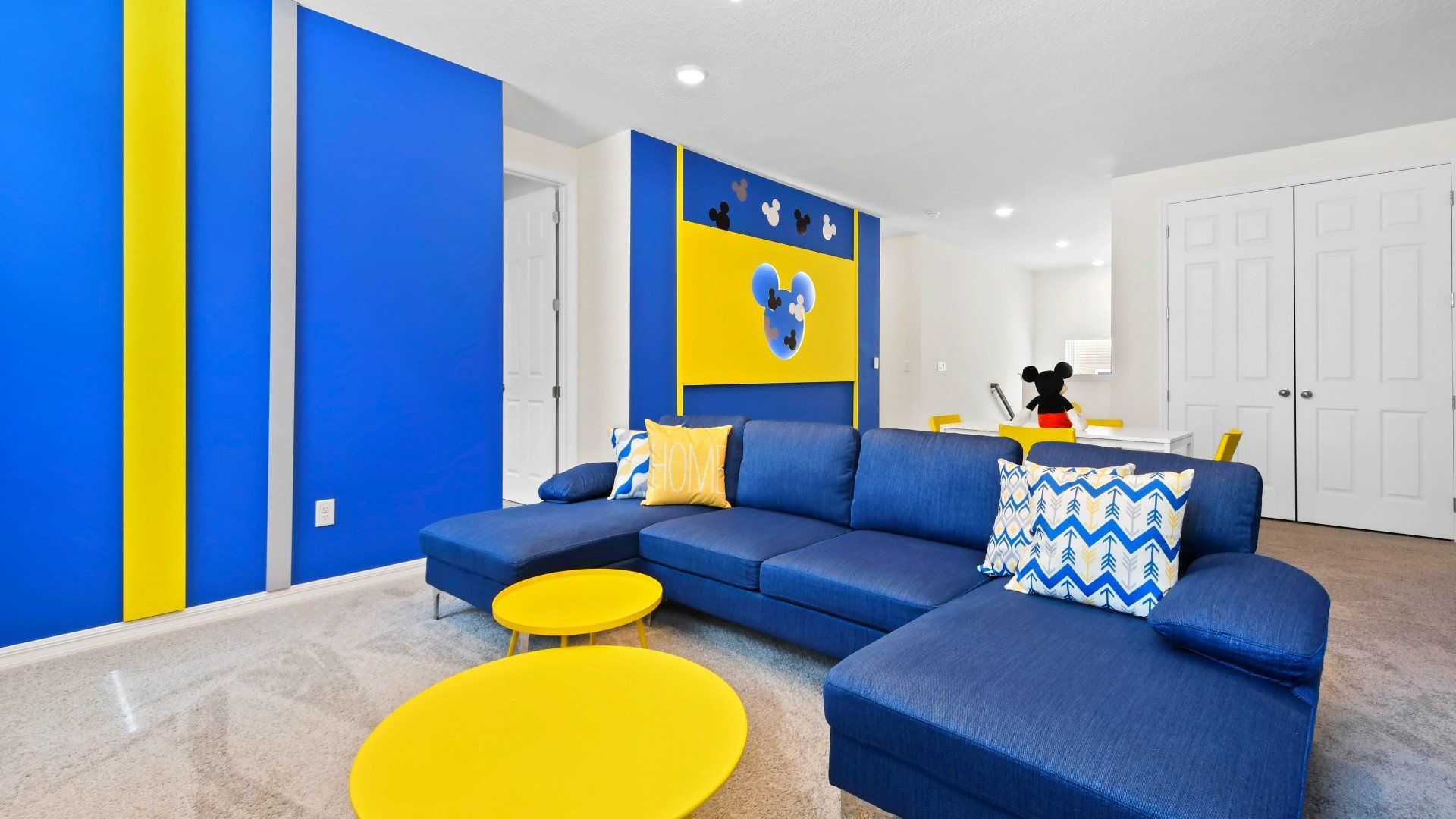 Bright Mickey-themed lounge with cozy seating, vibrant decor, and playful vibes!