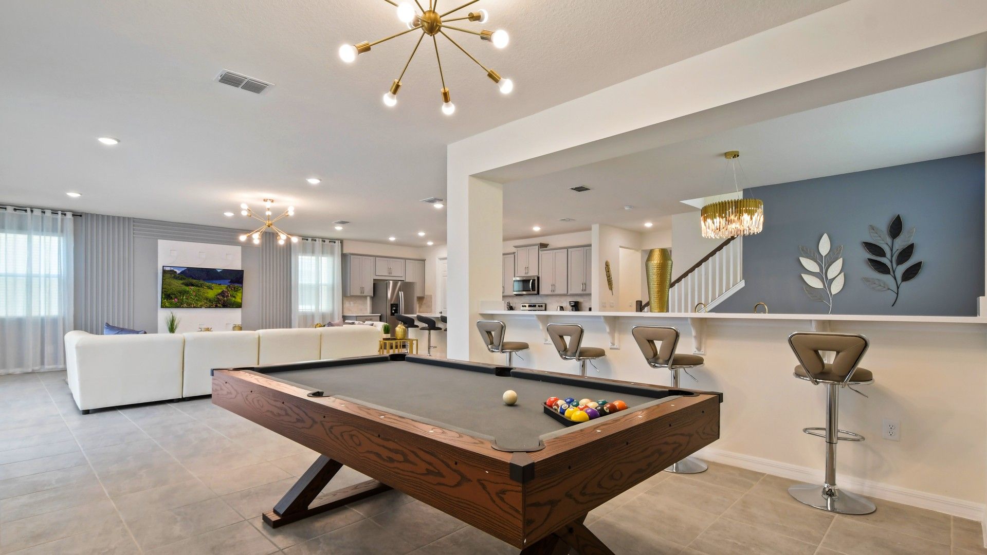 Stylish open-concept living with a pool table, modern kitchen, and bar seating!