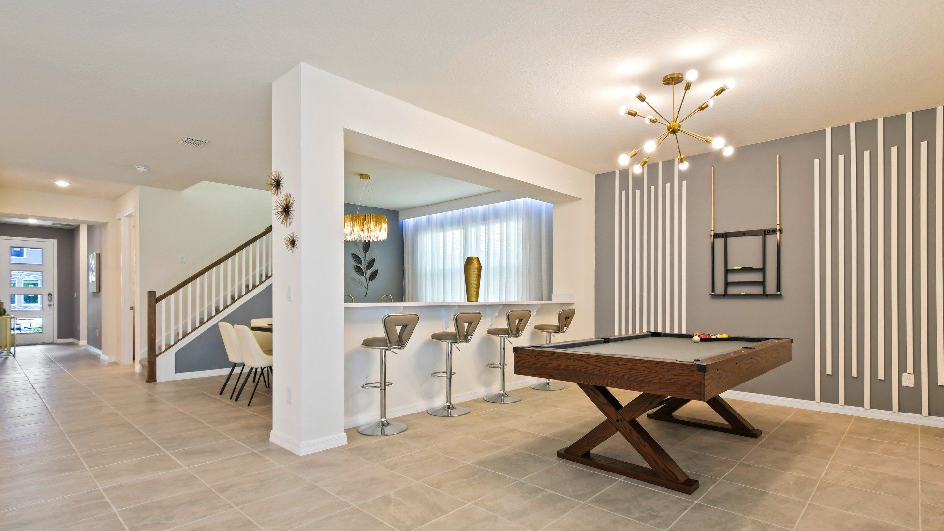 Modern game room with sleek pool table, stylish bar seating, and chic decor!