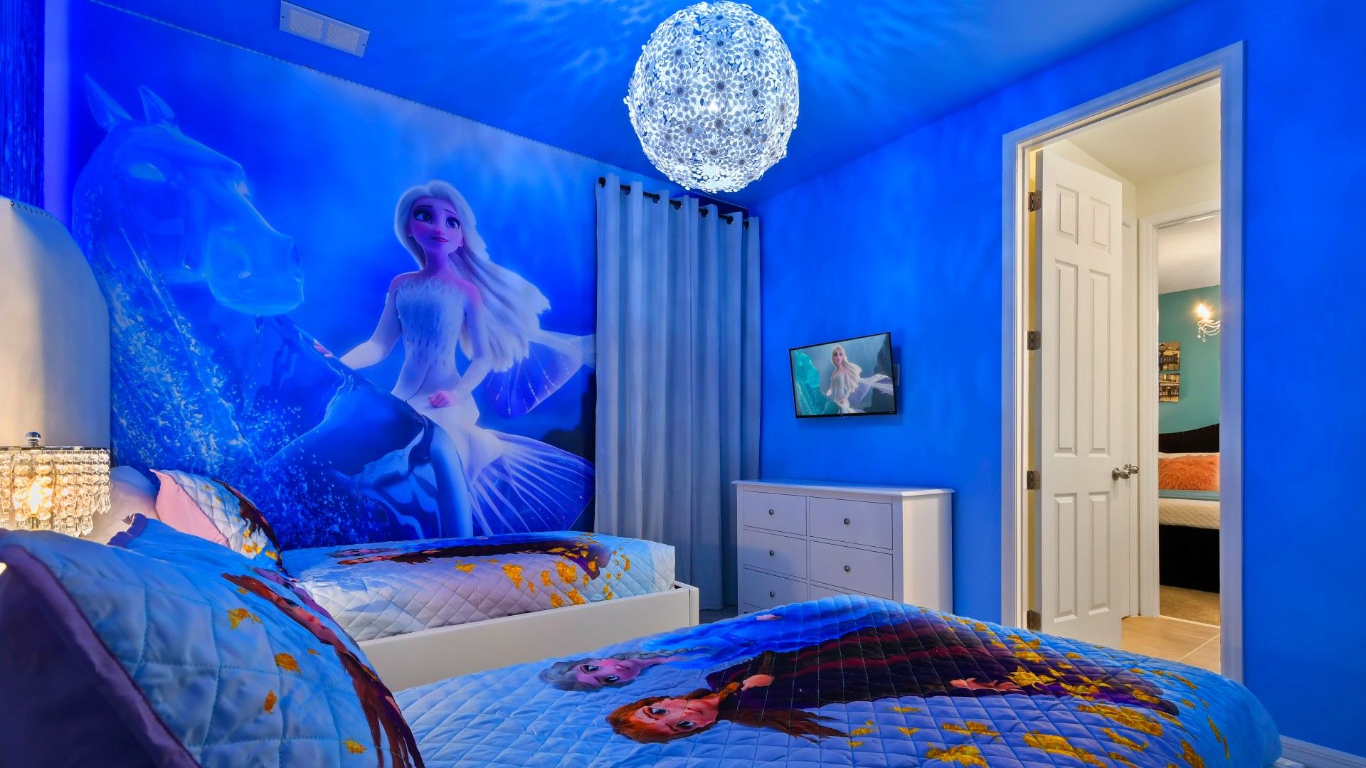 Magical Frozen-themed bedroom with glowing decor, vibrant walls, and cozy beds!