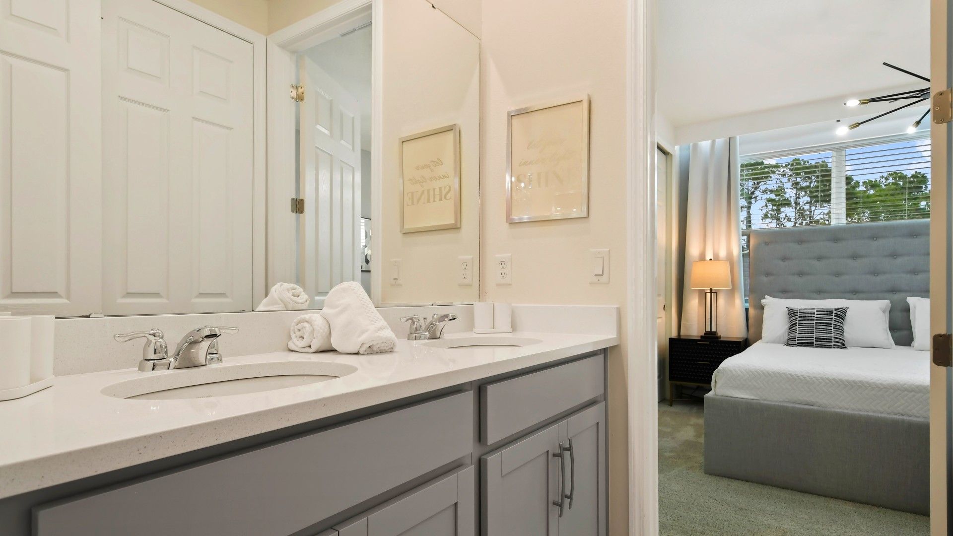 Stylish ensuite bathroom with dual sinks, soft towels, and modern decor.