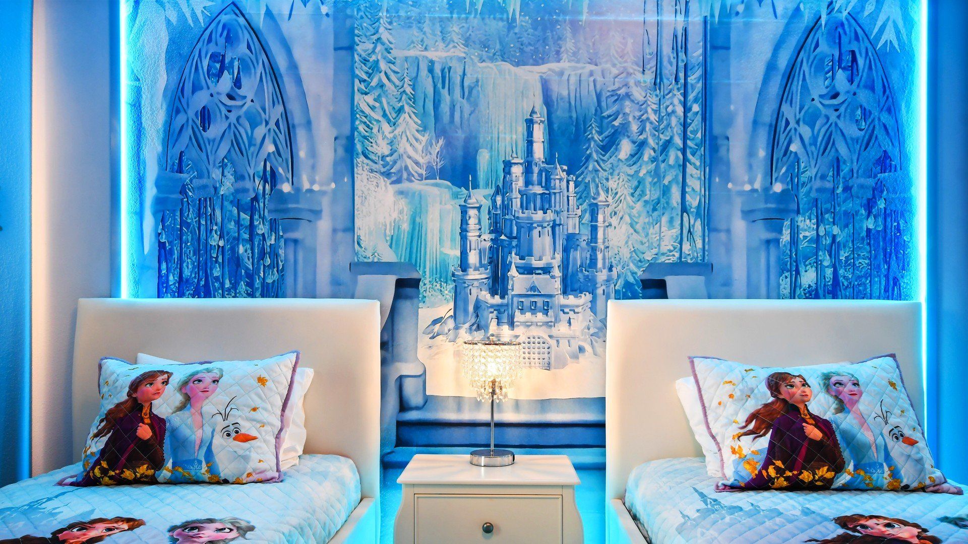 Frozen-inspired twin room with glowing castle mural and magical winter wonderland vibes.