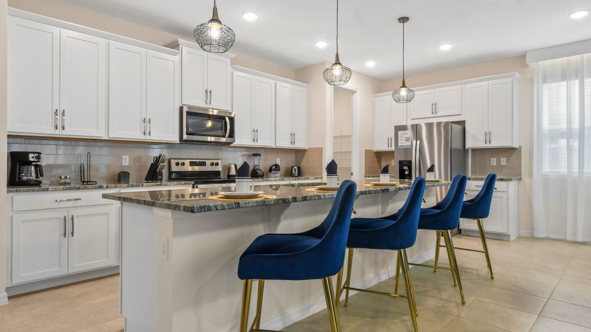 Modern Gourmet Kitchen: Sleek White Cabinets, Chic Blue Stools!