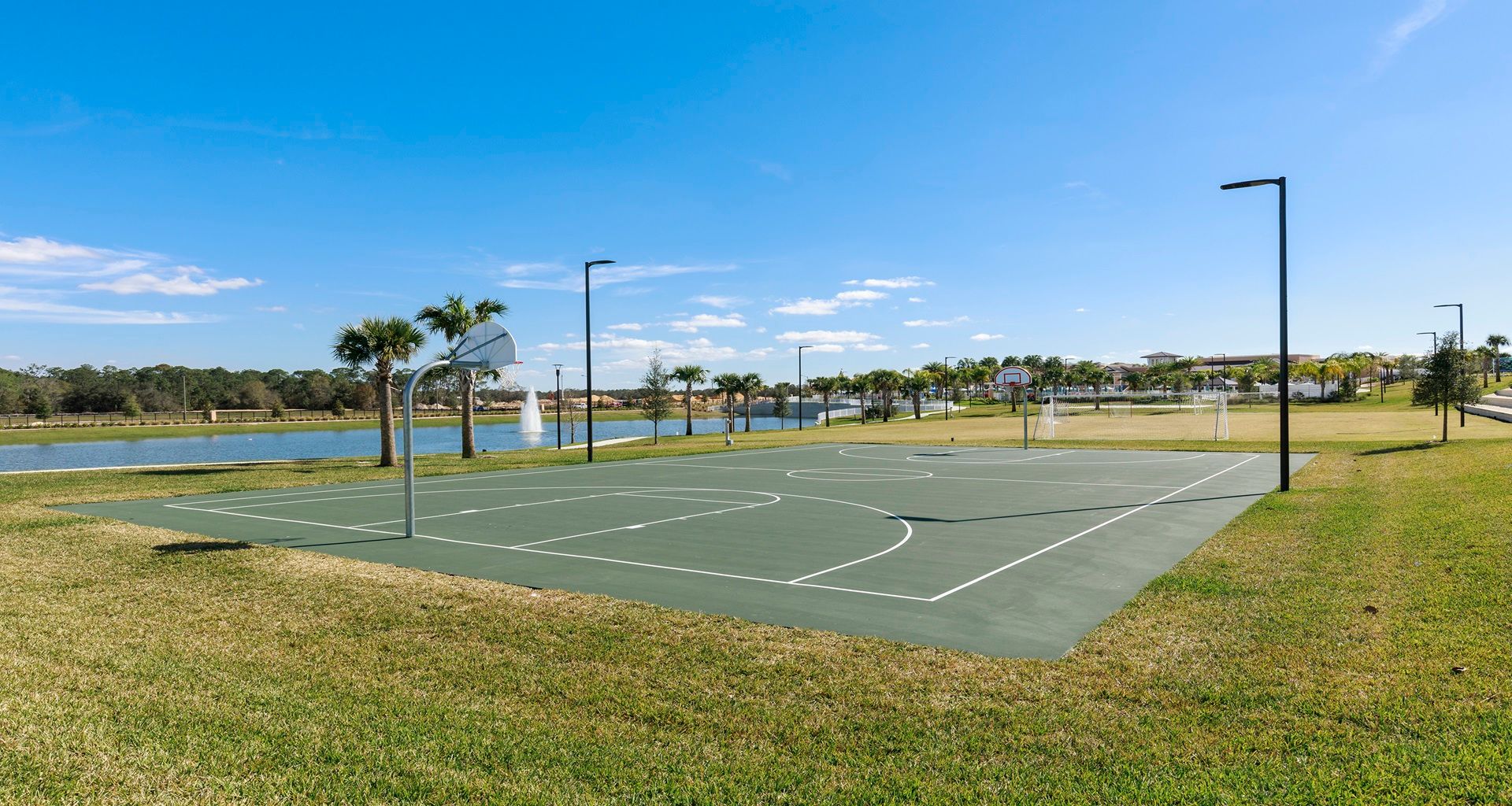 Scenic outdoor basketball court with lake views and open green space!