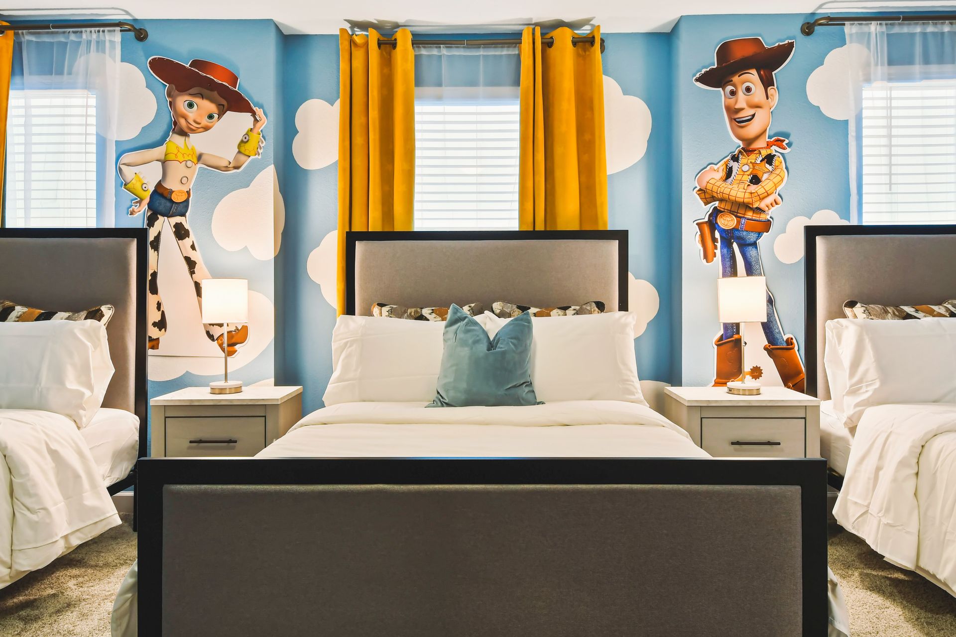 Toy Story-themed bedroom with three beds, playful wall art, and bright decor