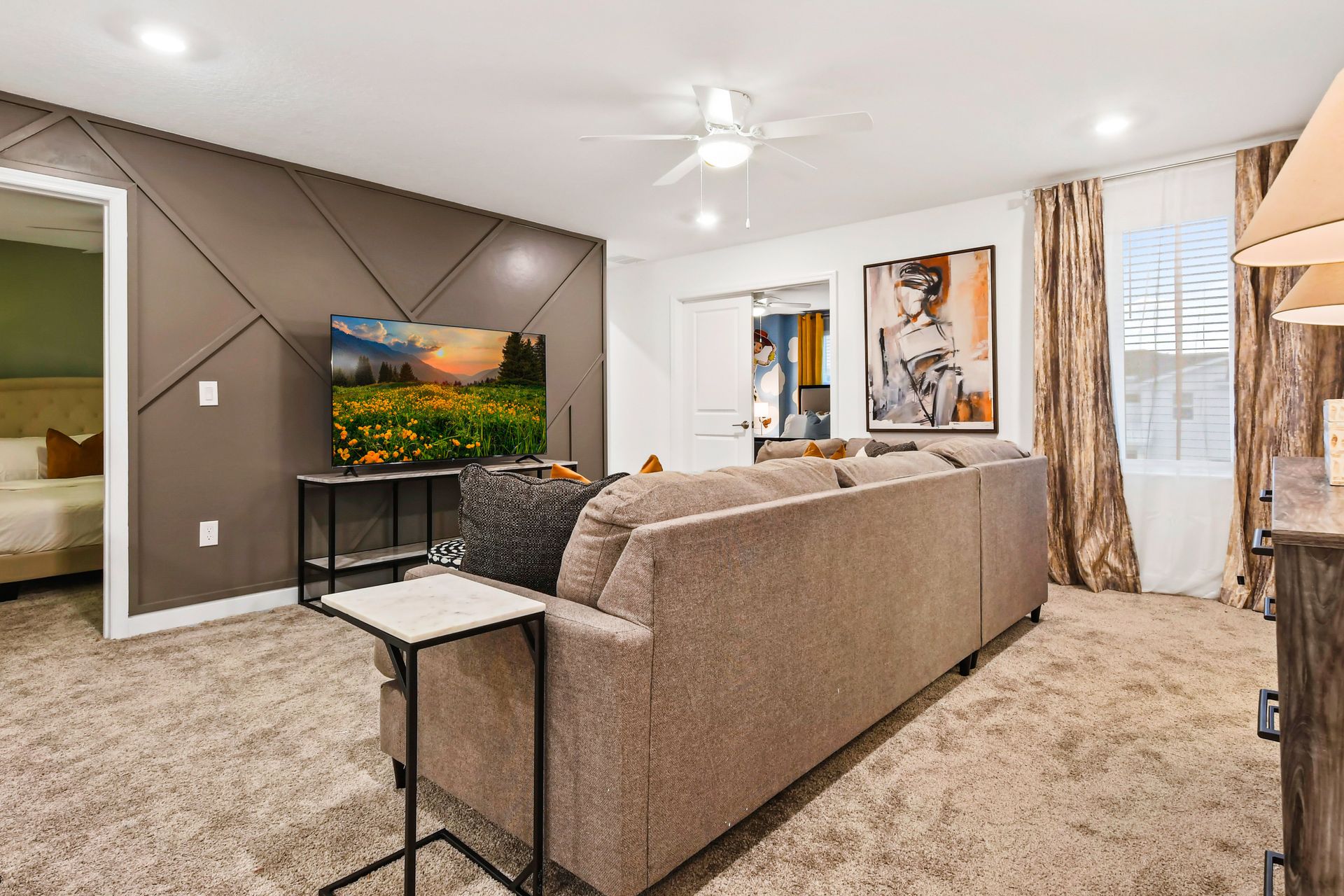 Cozy upstairs lounge with plush seating, smart TV, and access to themed bedrooms