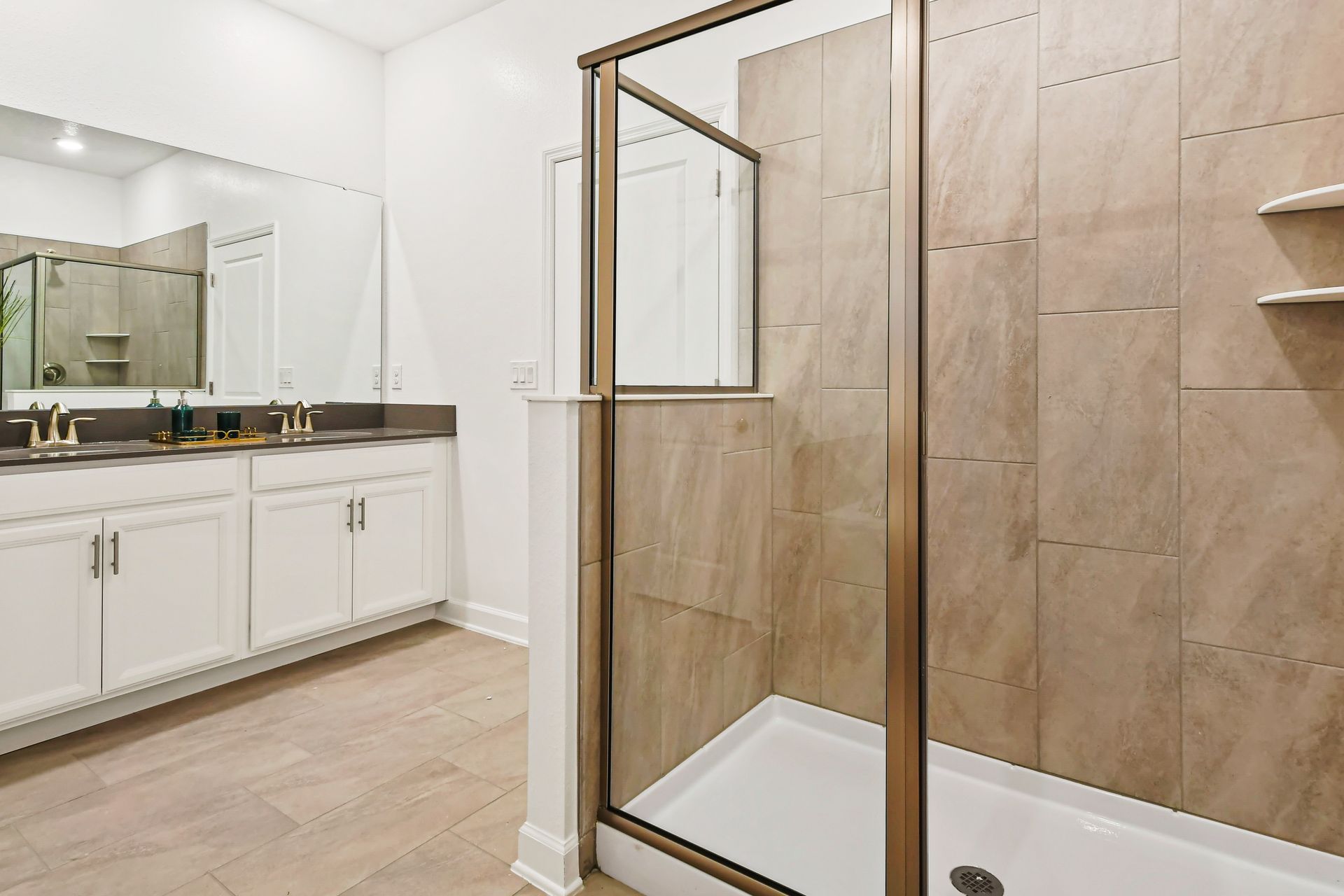 Spacious bathroom with walk-in shower, double sinks, and sleek modern finishes