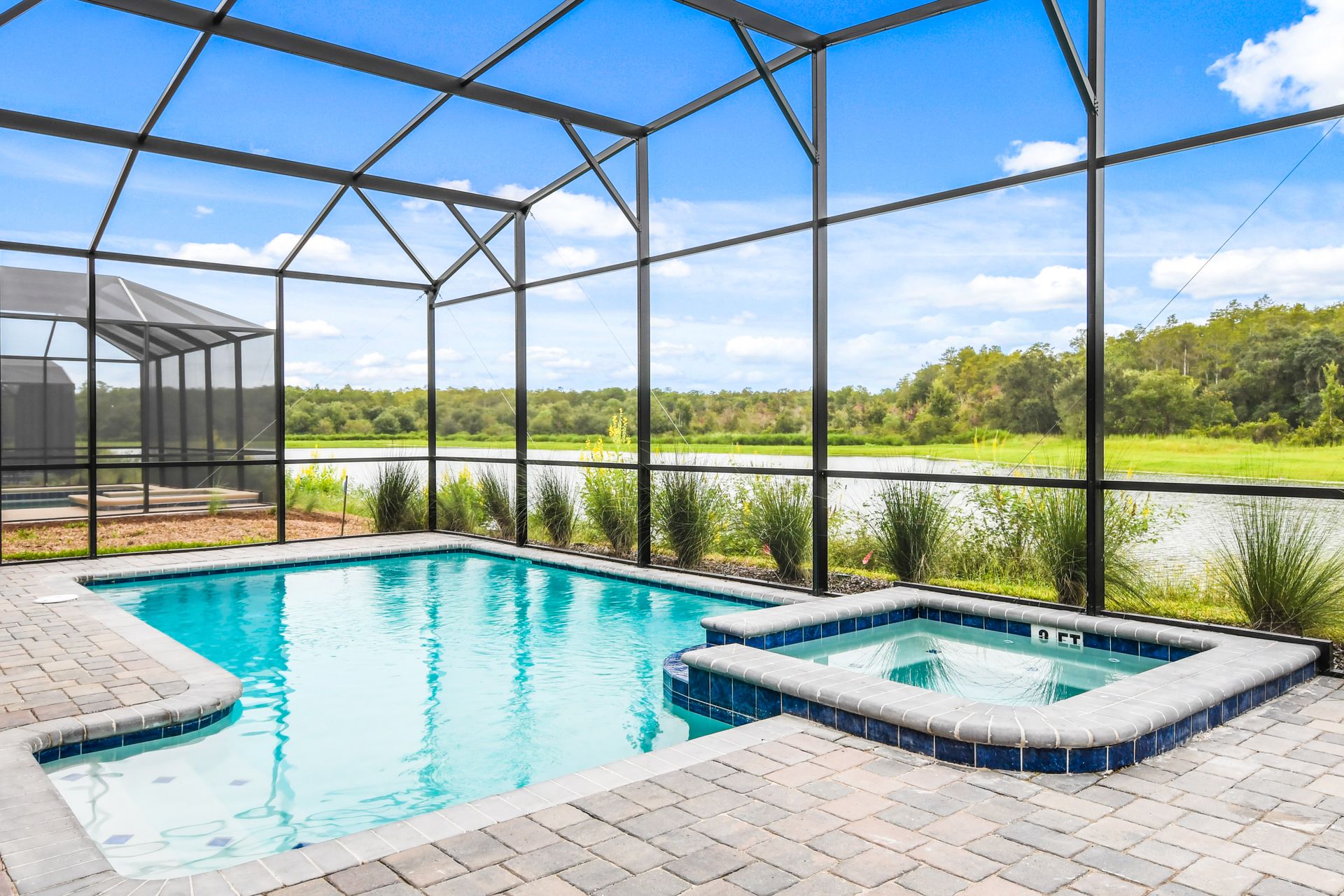 Private screened pool and spa with serene lake views and sunny relaxation vibes