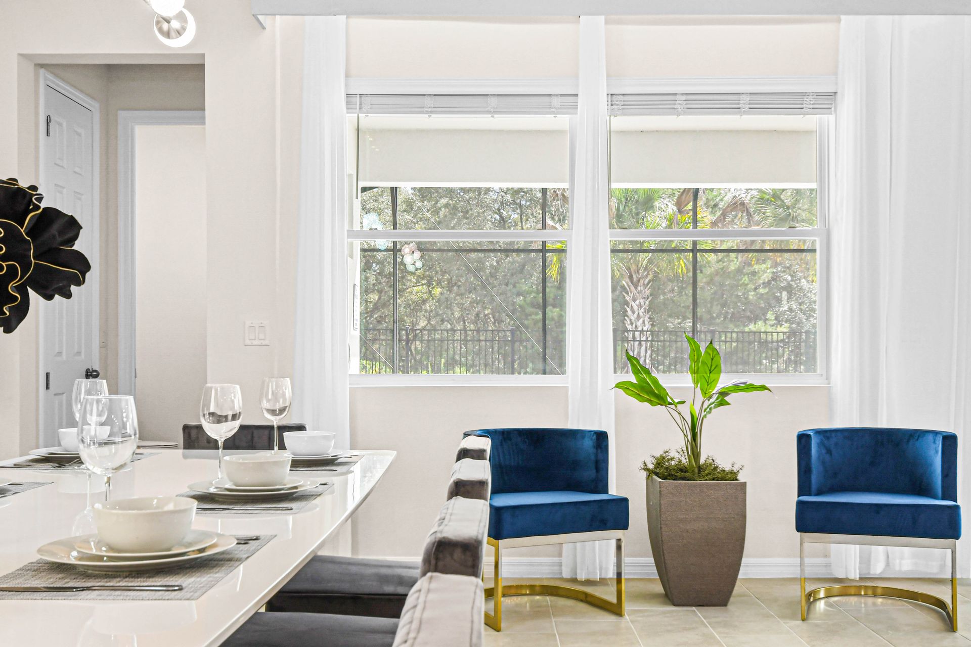 Cozy dining area with elegant table settings, vibrant blue chairs, and garden views.