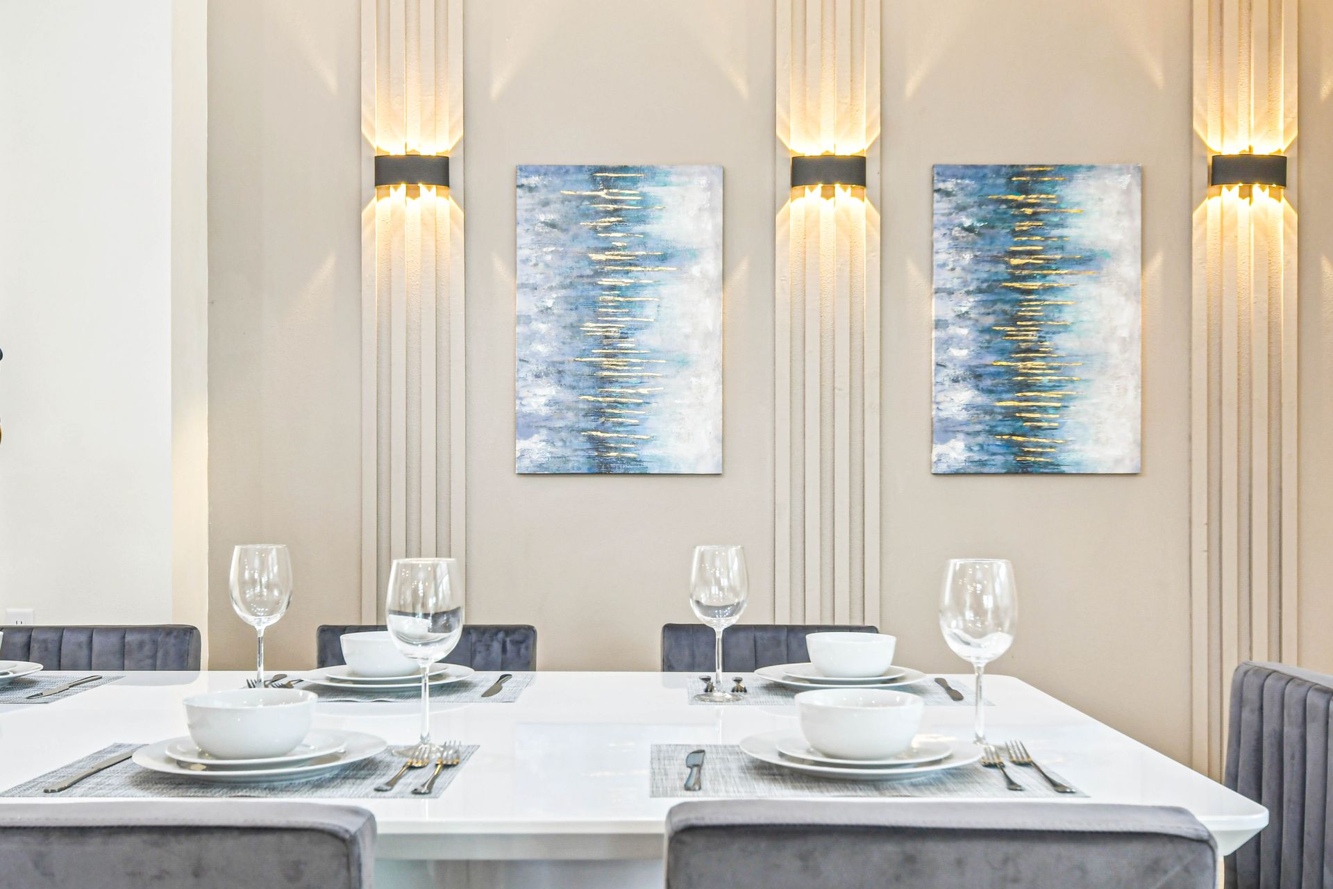 Elegant dining area with modern art, plush seating, and chic lighting.