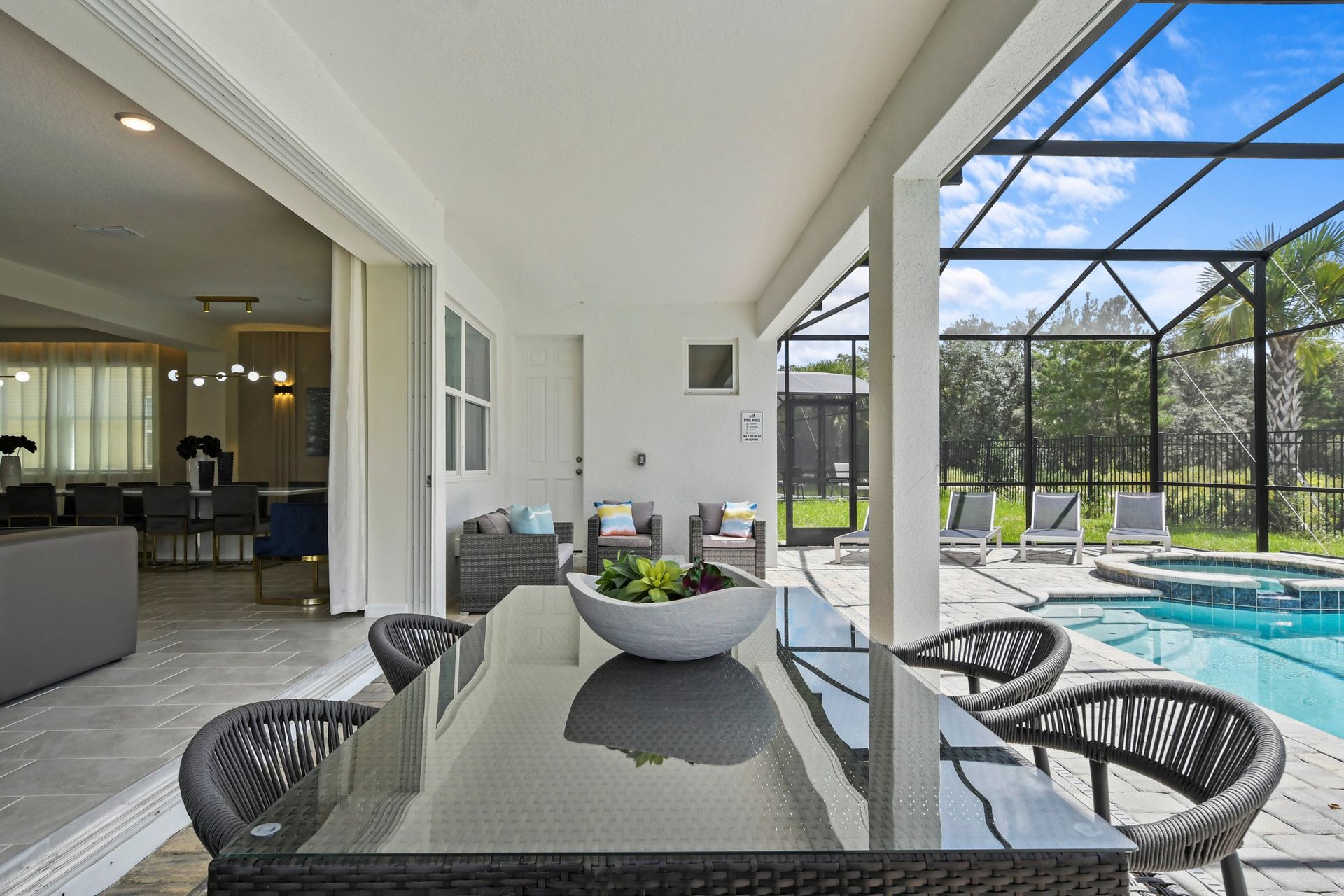 Covered outdoor dining area with poolside seating, perfect for relaxing and entertaining.