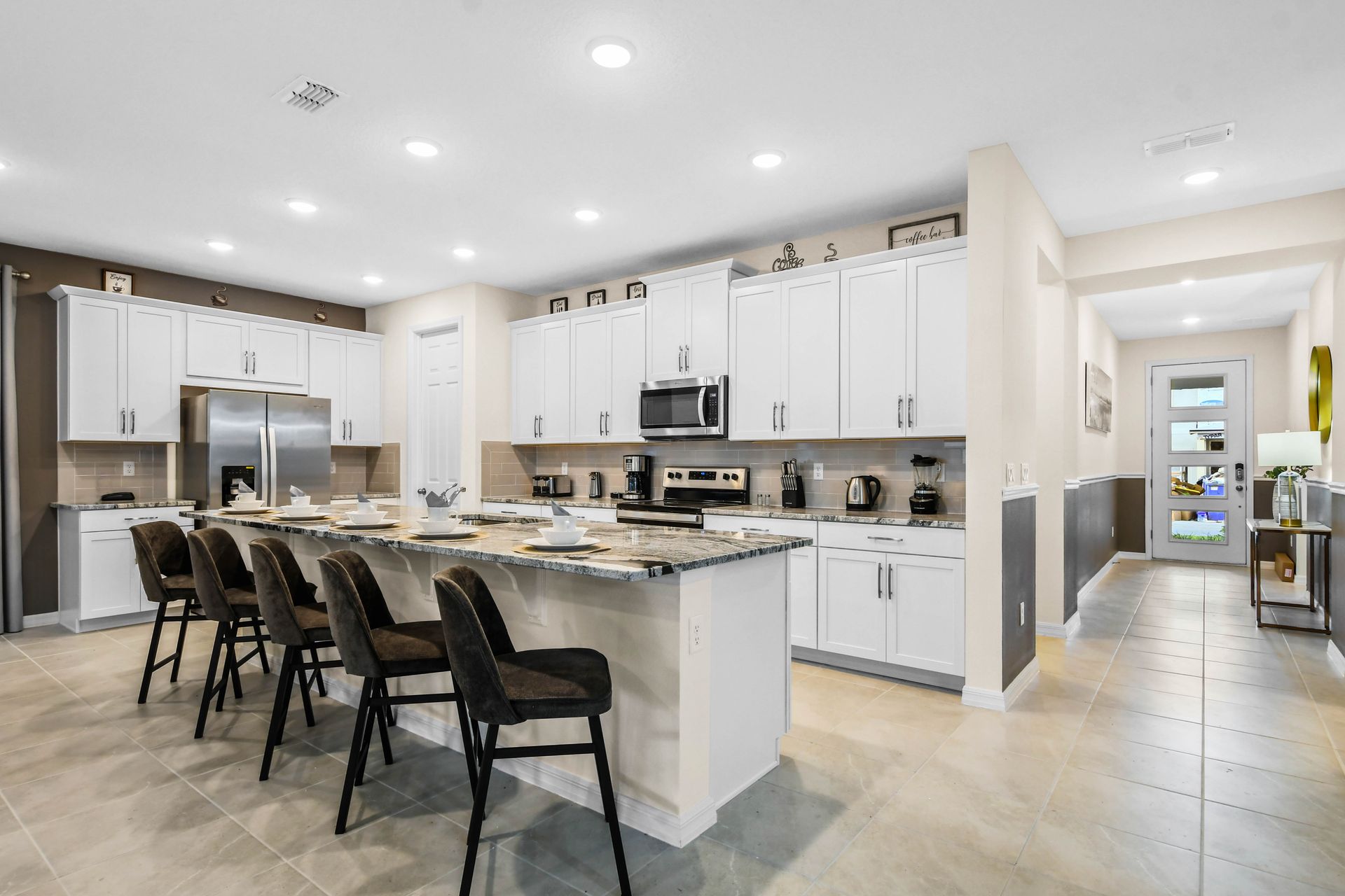 Fully equipped kitchen with granite island, bar seating, and modern design