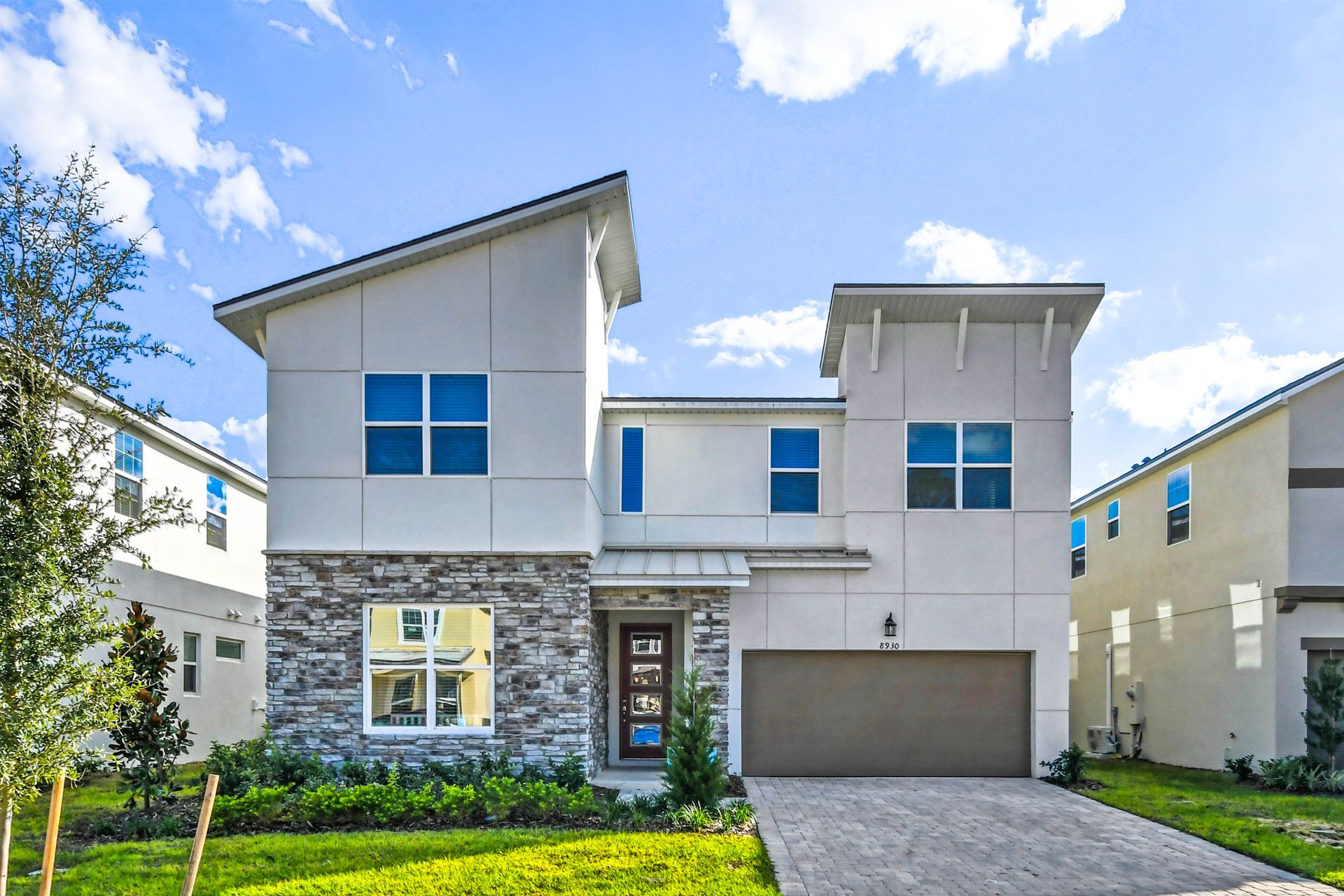 Modern luxury villa with sleek design, stone accents, and spacious layout!