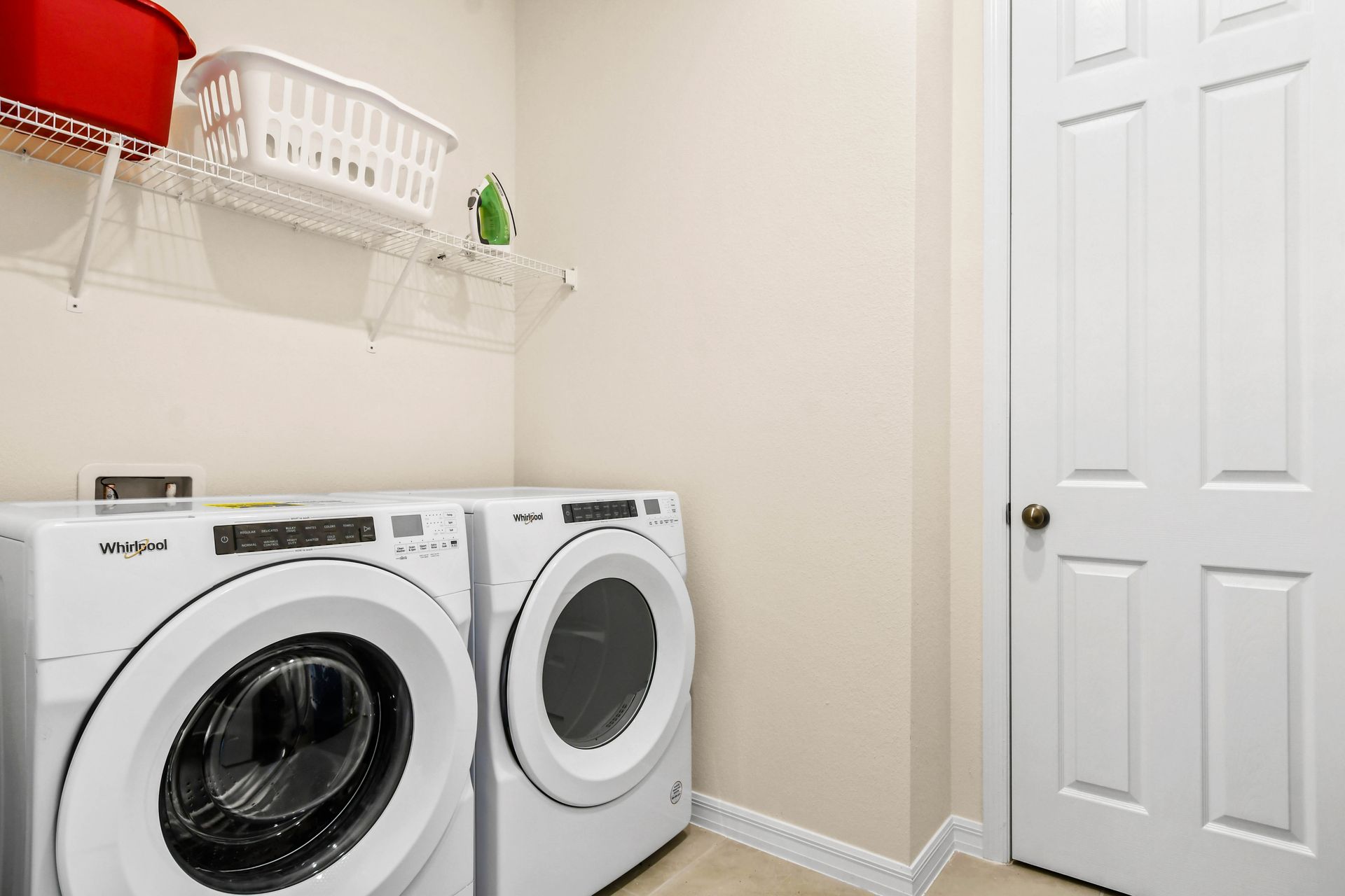 Convenient laundry room with modern washer, dryer, and storage shelf!