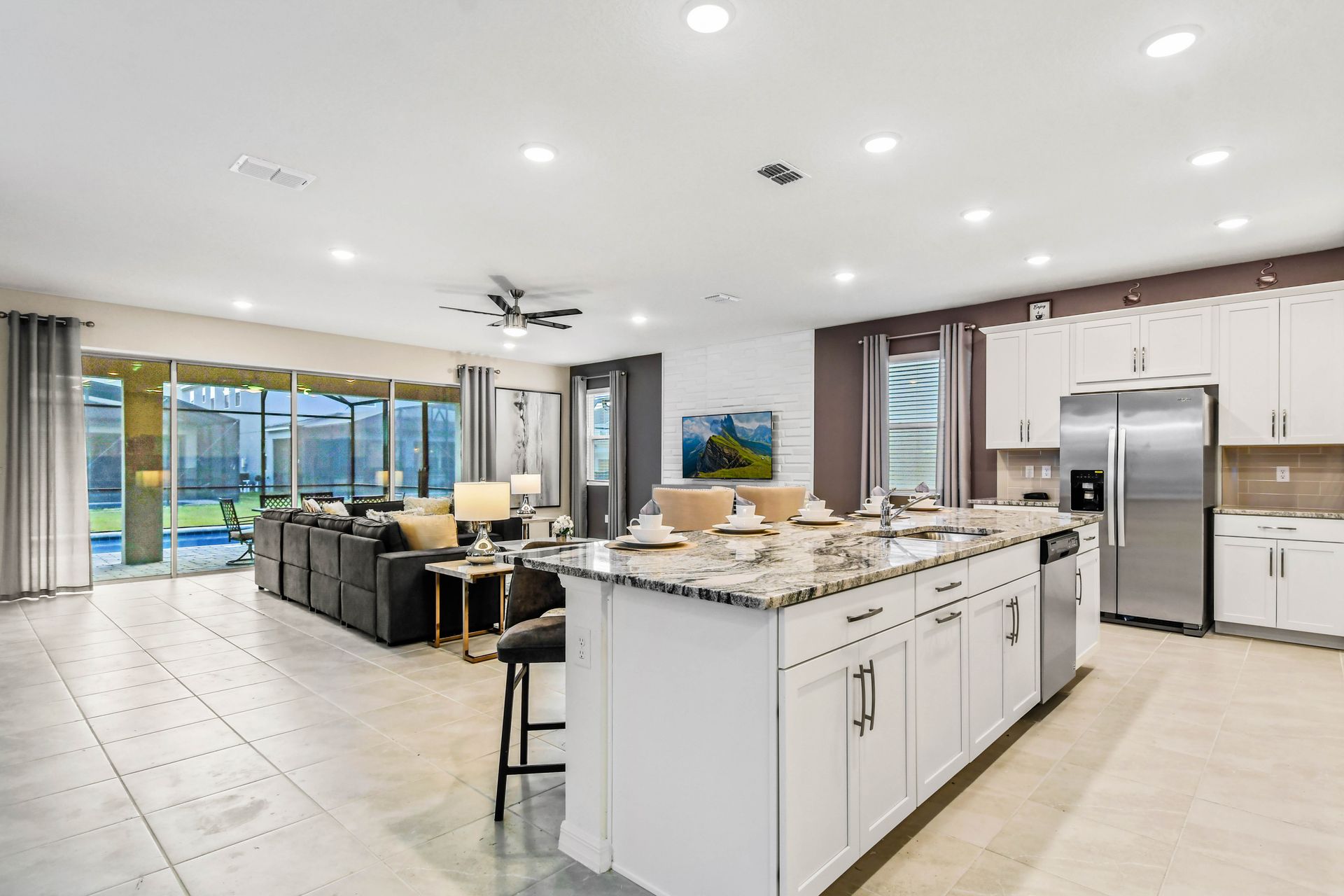 Bright open kitchen with granite island, stainless appliances, and pool view!