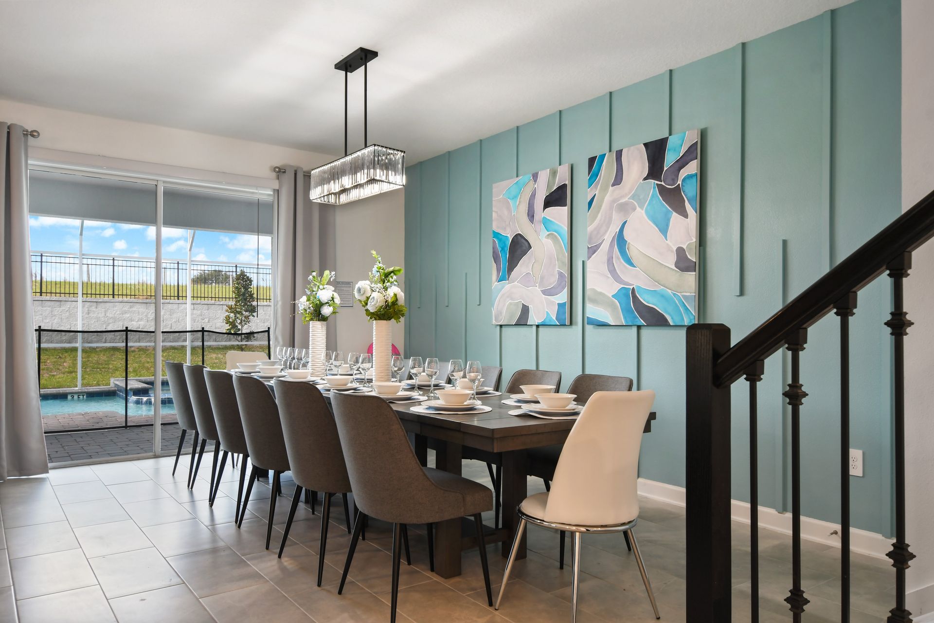 Elegant dining space for 12 with pool views, modern art, and vibrant accents.