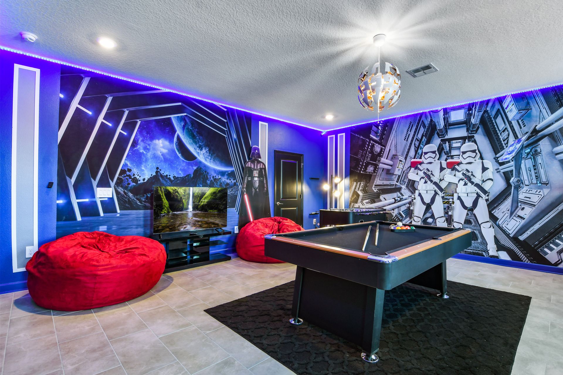 Epic galactic game room with bean bags, pool table, foosball, and LED lighting.