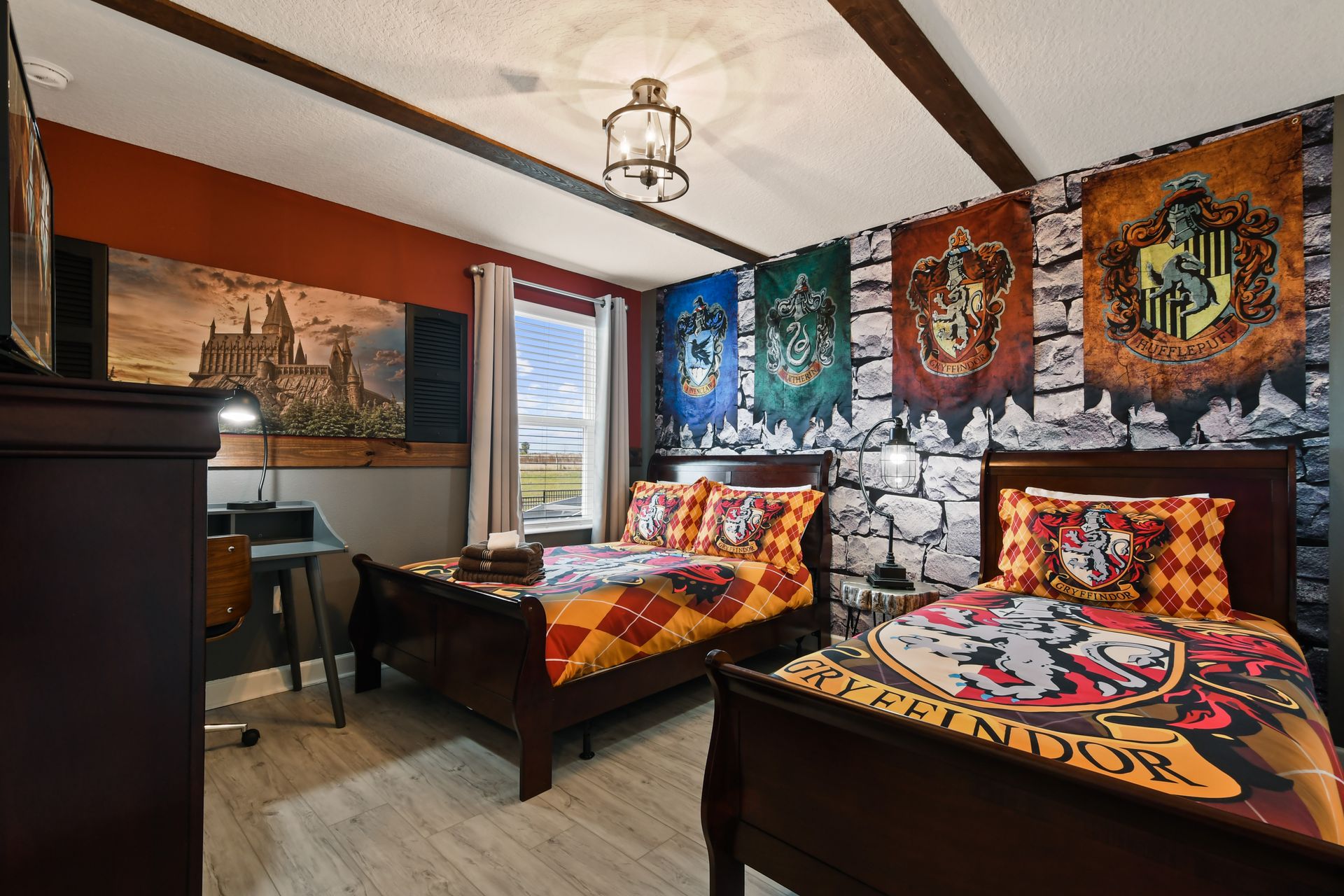 Wizarding-themed twin room with house banners, castle art, and magical charm.