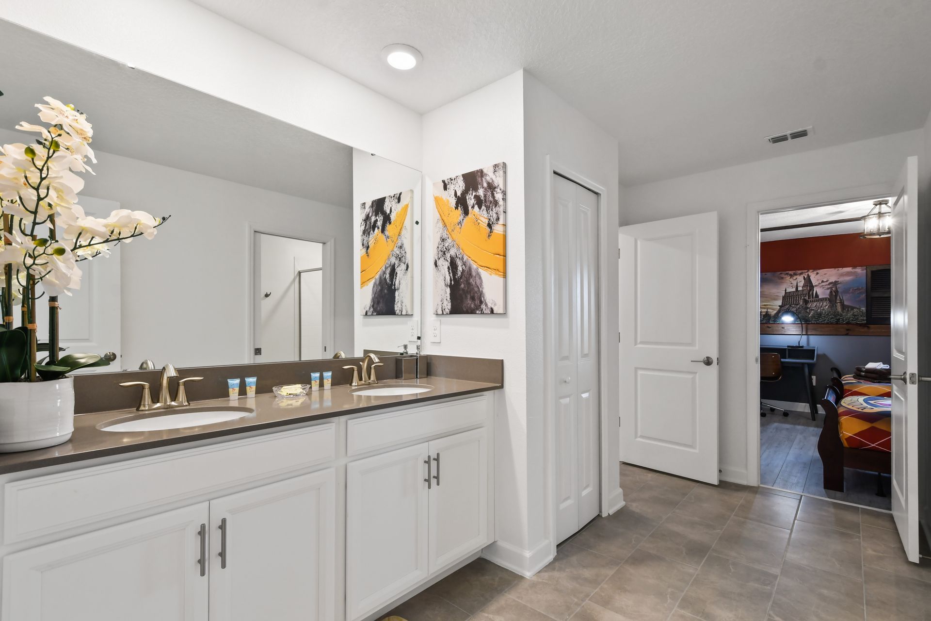 Spacious double sink bathroom with modern design and themed bedroom access.