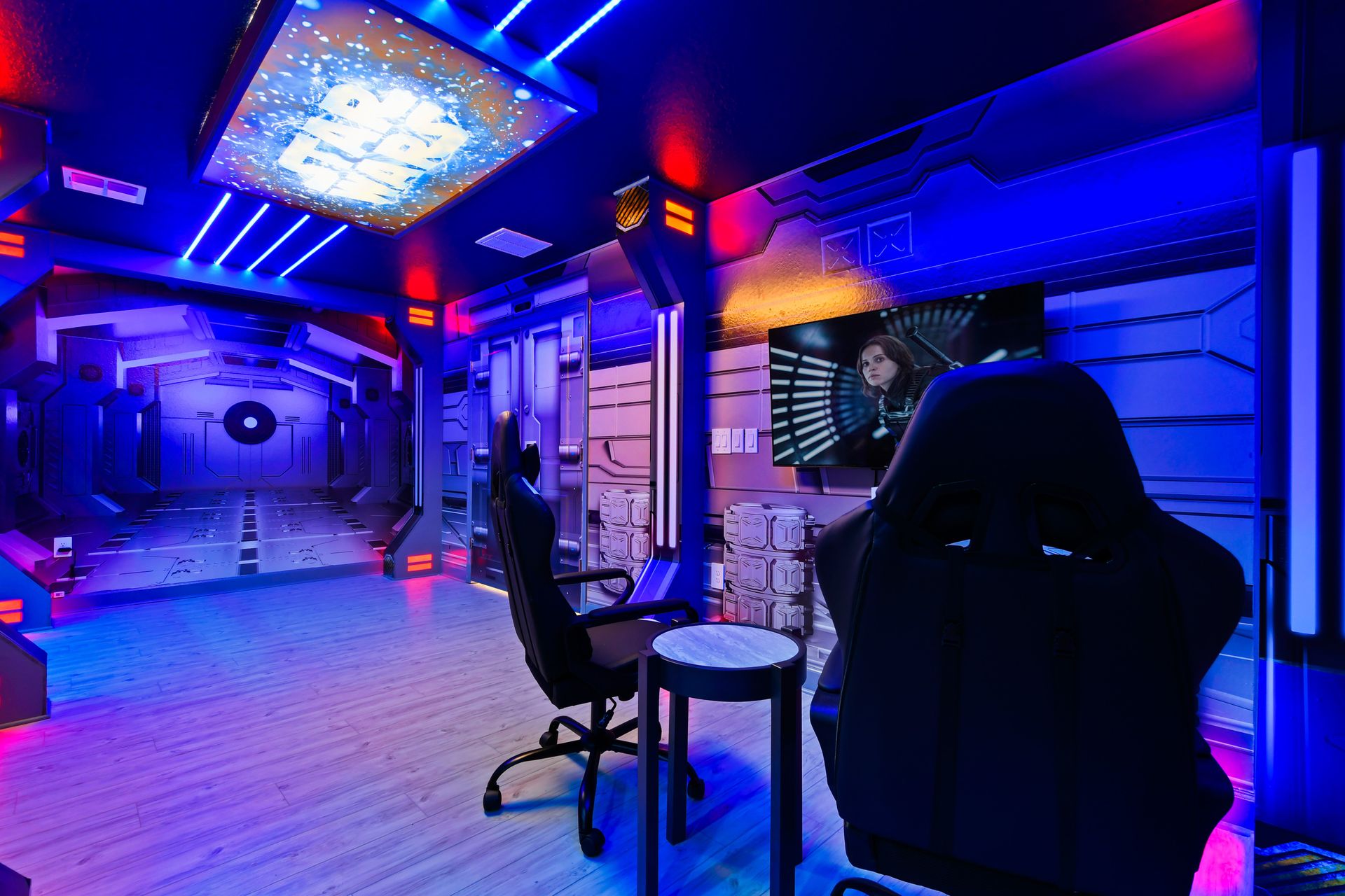 Futuristic space-themed bedroom featuring LED ceiling lights, immersive wall murals, gaming chairs, and custom-built bunk beds styled like spaceship pods.