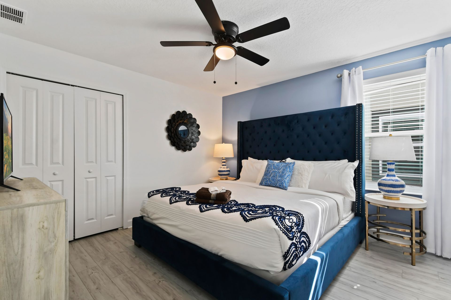 Elegant bedroom with deep blue accents, plush king bed, and stylish modern decor.