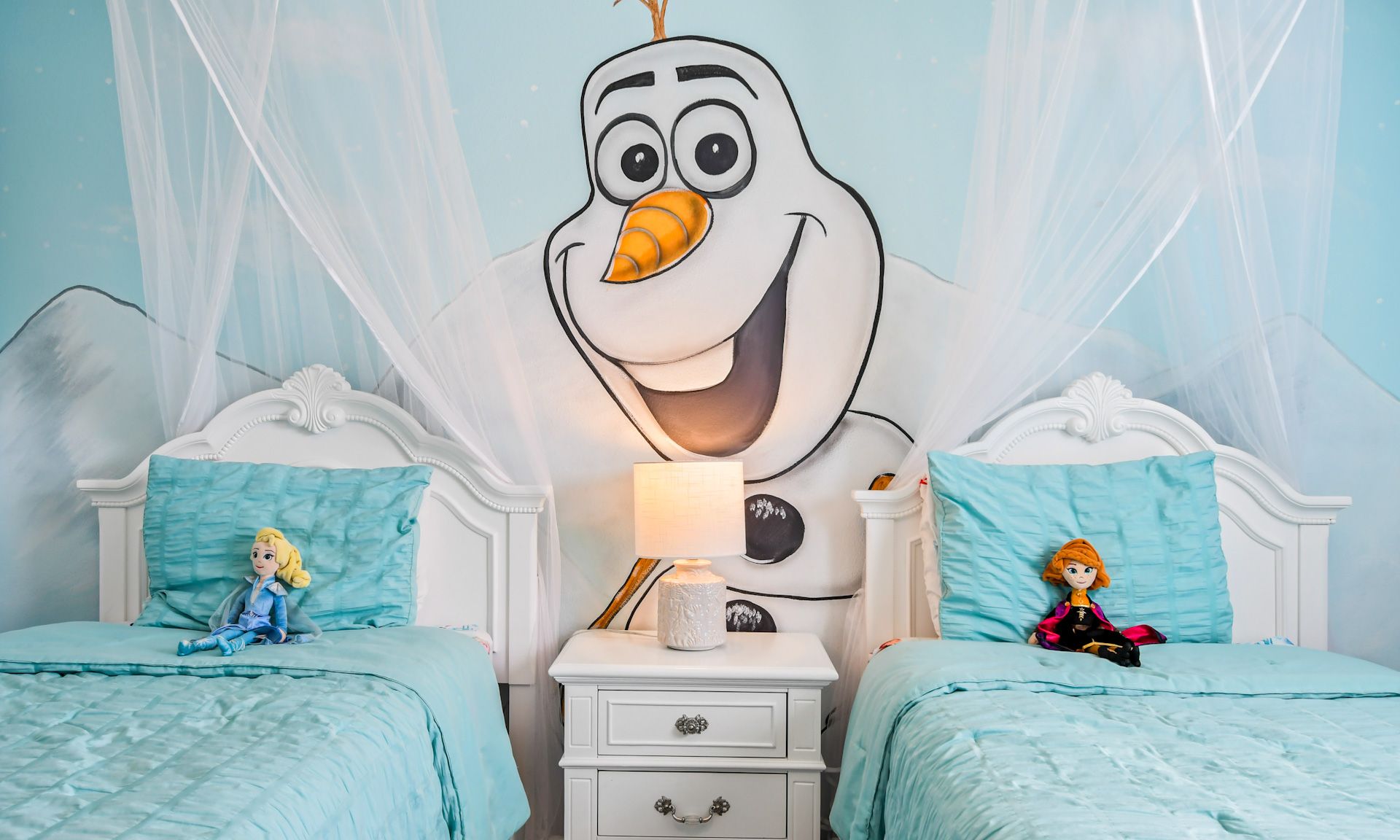 Frozen-themed kids' room with twin beds, adorable snowman wall art, and magical decor for a cozy stay.