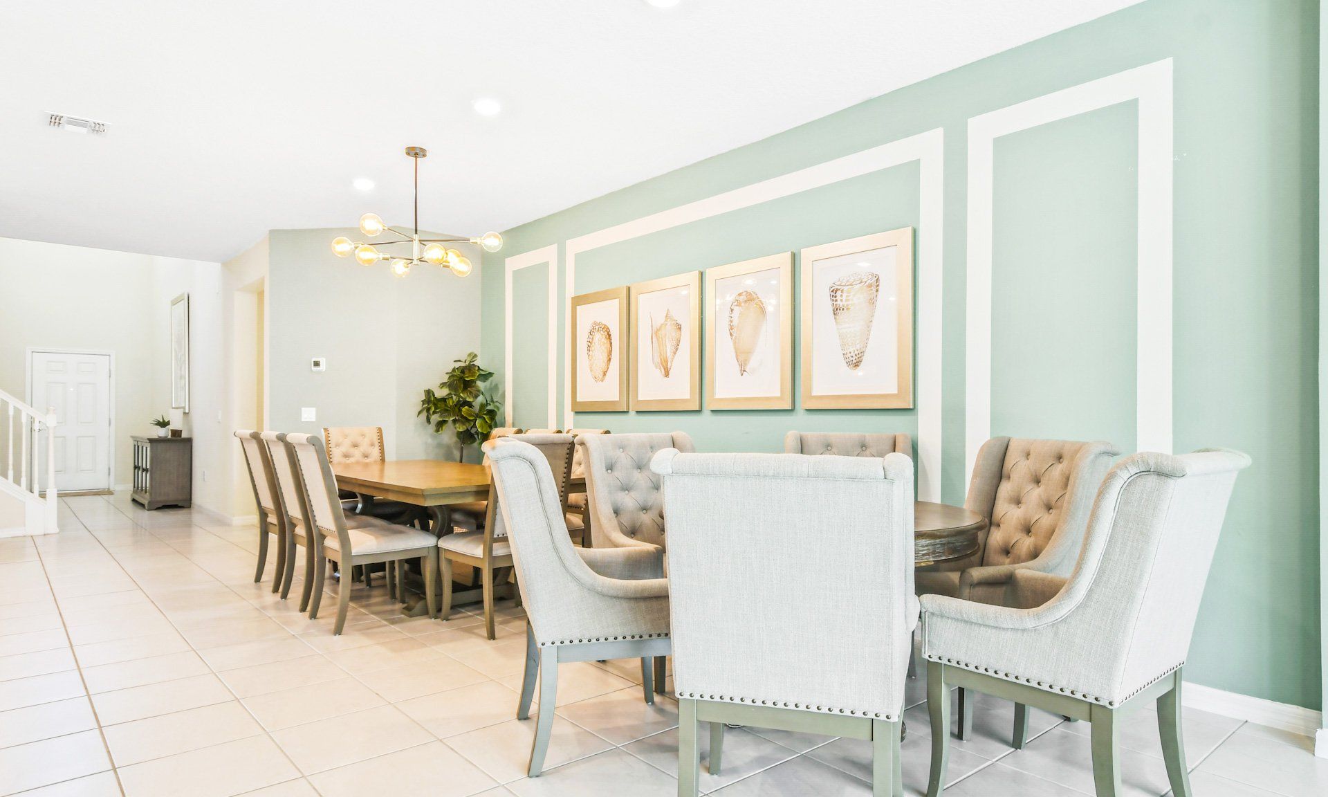Chic dining area with elegant chairs, coastal wall art, and stylish lighting for a welcoming ambiance.