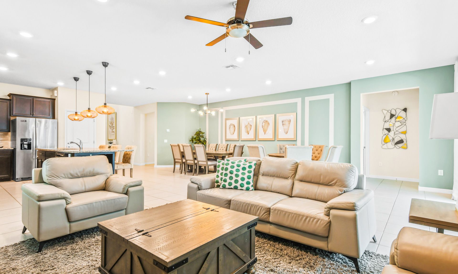 Open-concept living space with comfy seating, elegant dining area, and modern kitchen island lighting.