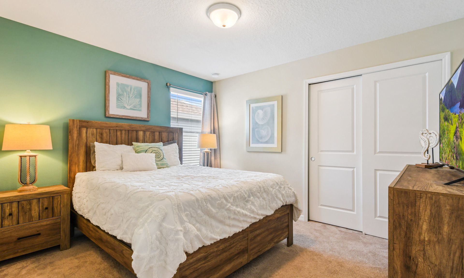 Charming bedroom with queen bed, rustic wooden furniture, cozy lighting, and a serene green accent wall.