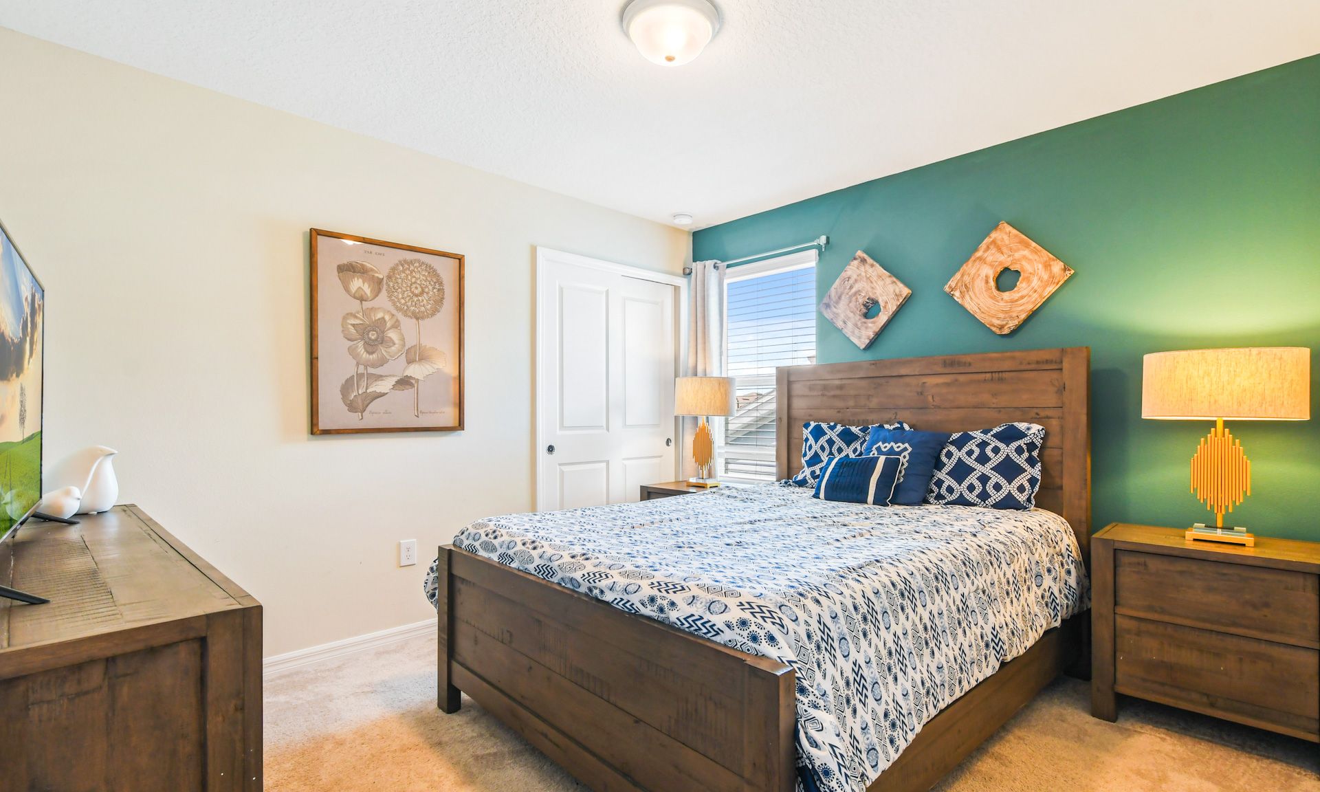Inviting bedroom with queen bed, bold green accent wall, stylish decor, and rustic wooden furniture.