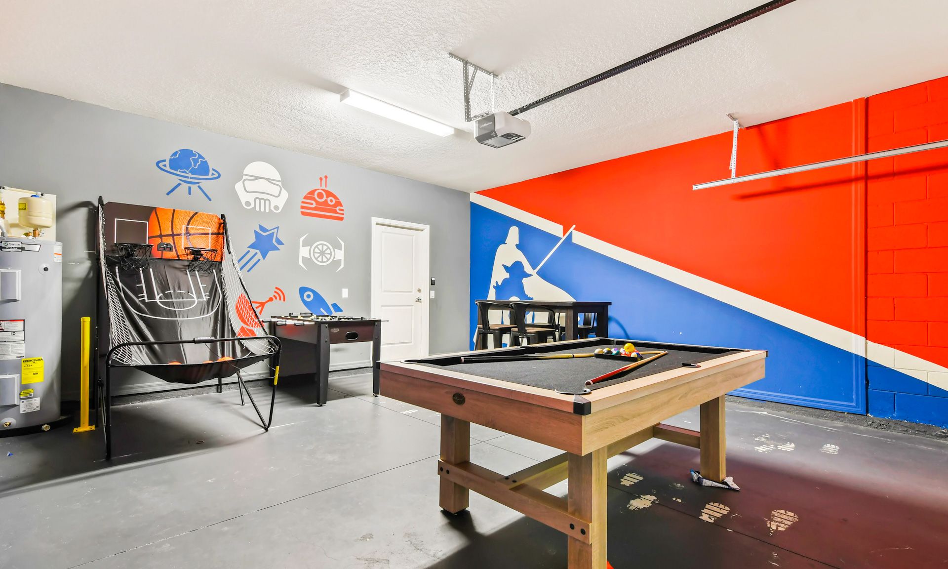 Colorful game room with pool table, basketball shootout, foosball, and fun space-themed decor.