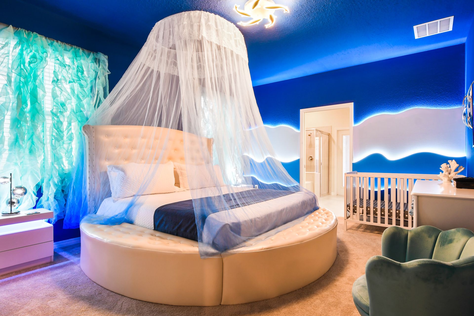 The master bedroom features a luxuriously large king bed with a crib