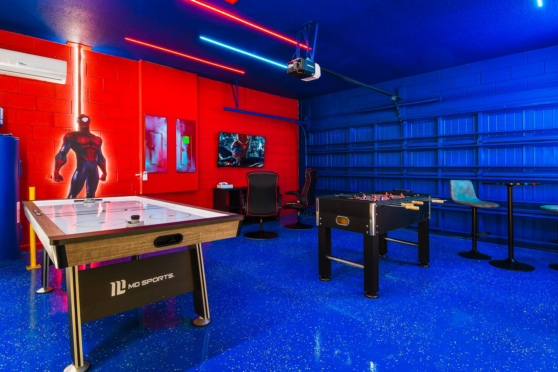 Vibrant superhero game room with neon lights, air hockey, foosball, and lounge area