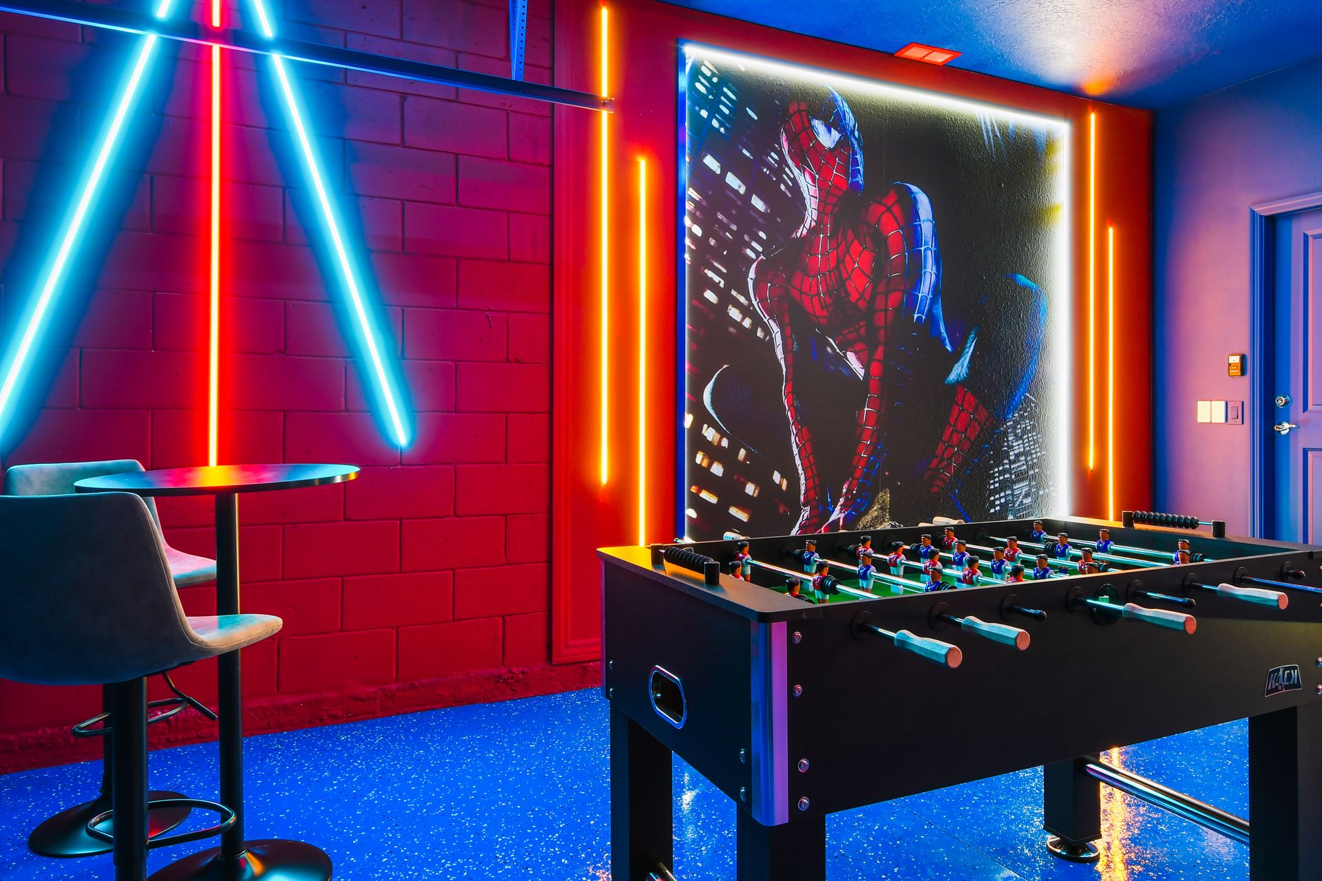 Action-packed superhero game room with neon lights, foosball, and bold wall art