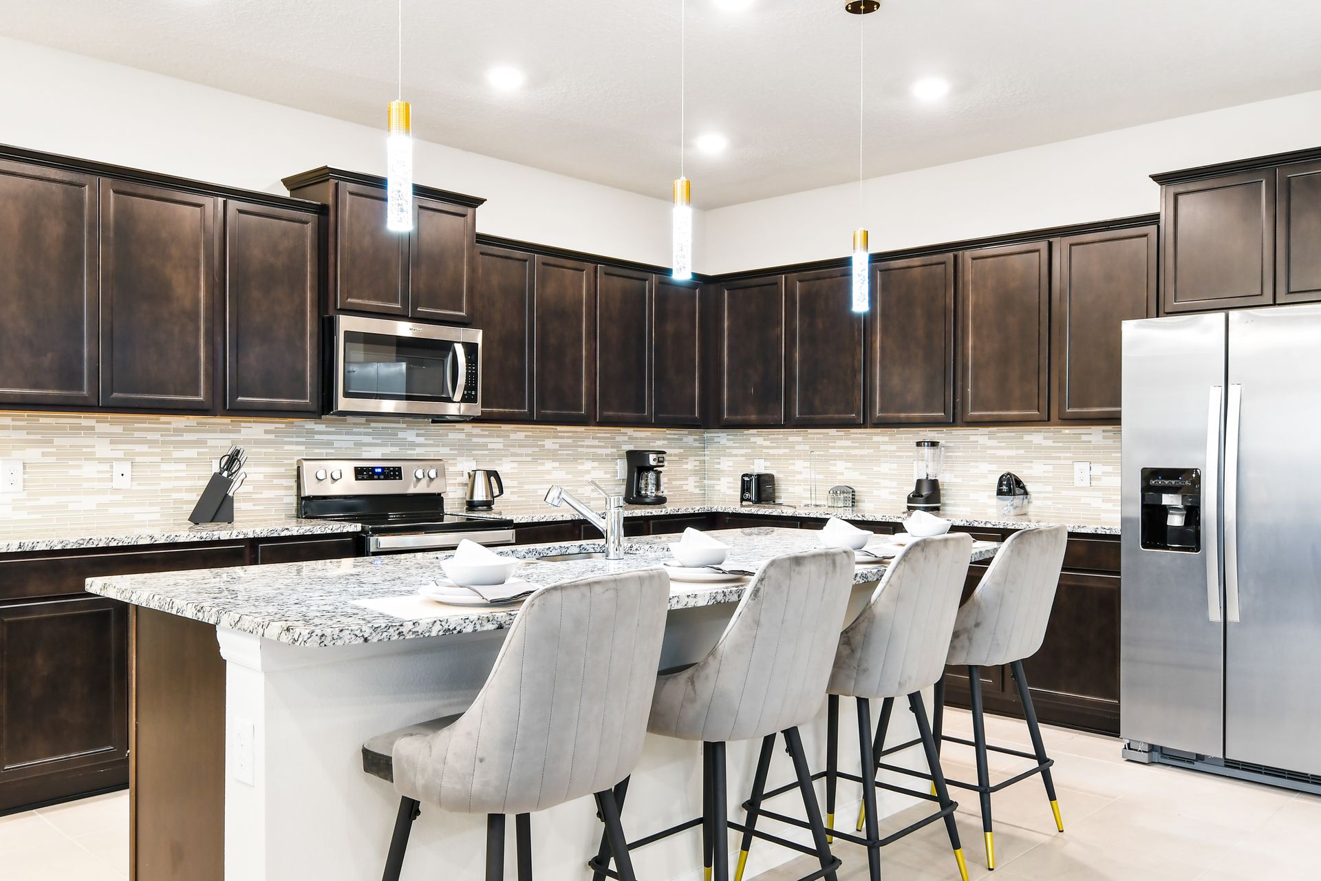 Sleek chef’s kitchen with granite island, modern appliances, and elegant seating