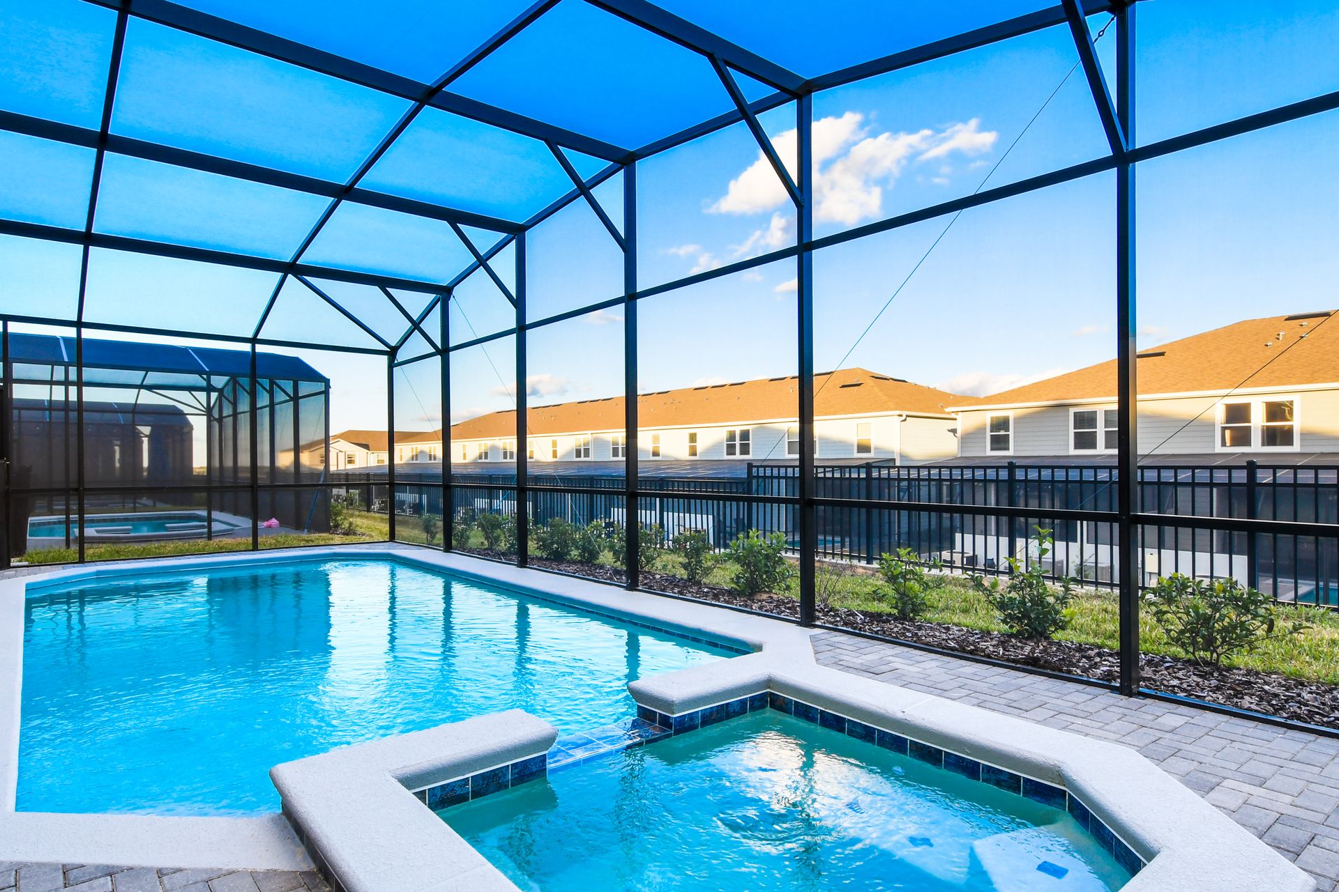 Private screened pool and spa with comfy lounge seating and shaded patio area